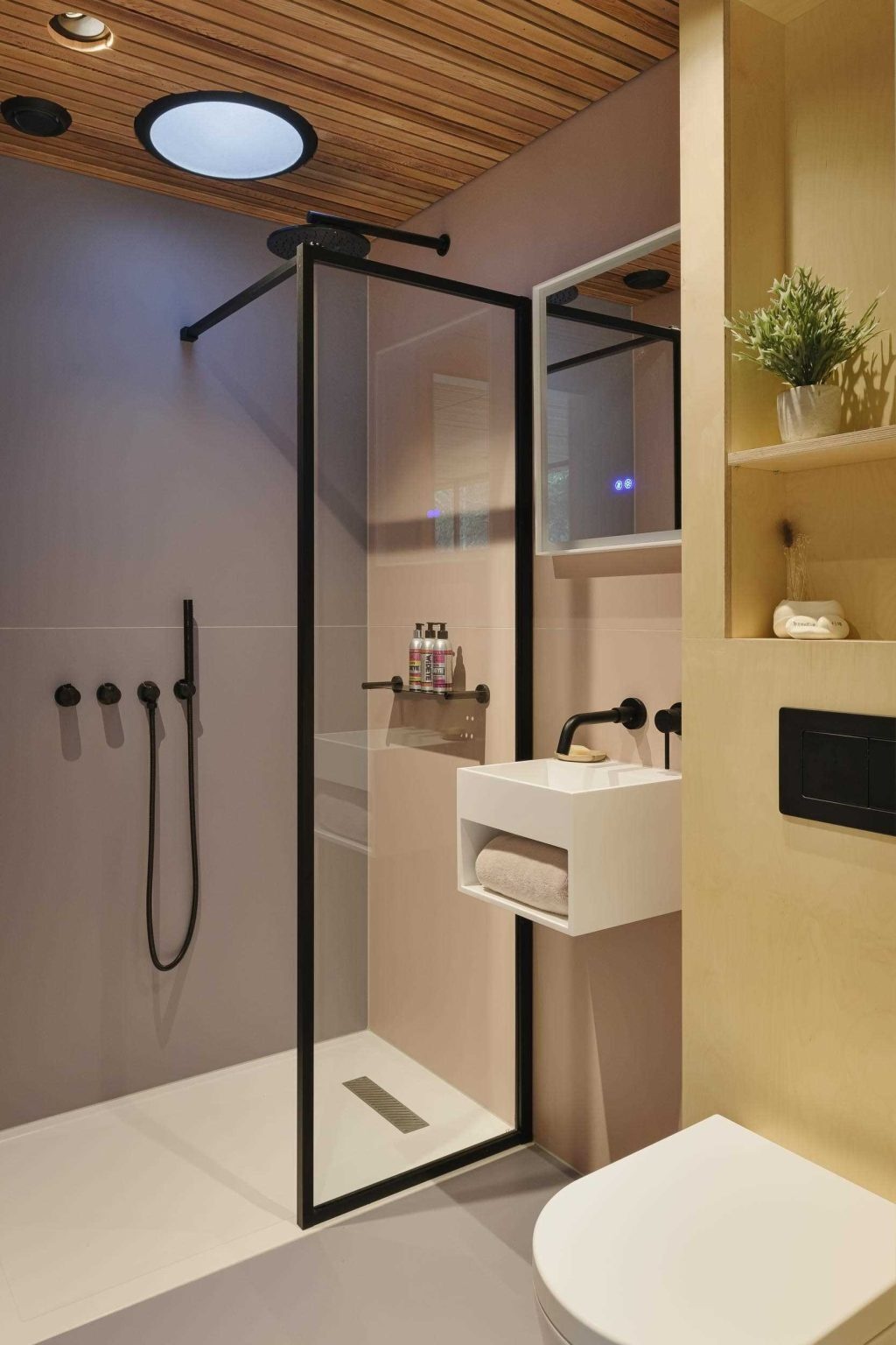 From a freestanding bathtub beside the windows to custom built-in shelving, this bedroom makes the surrounding woodland part of the interior experience.