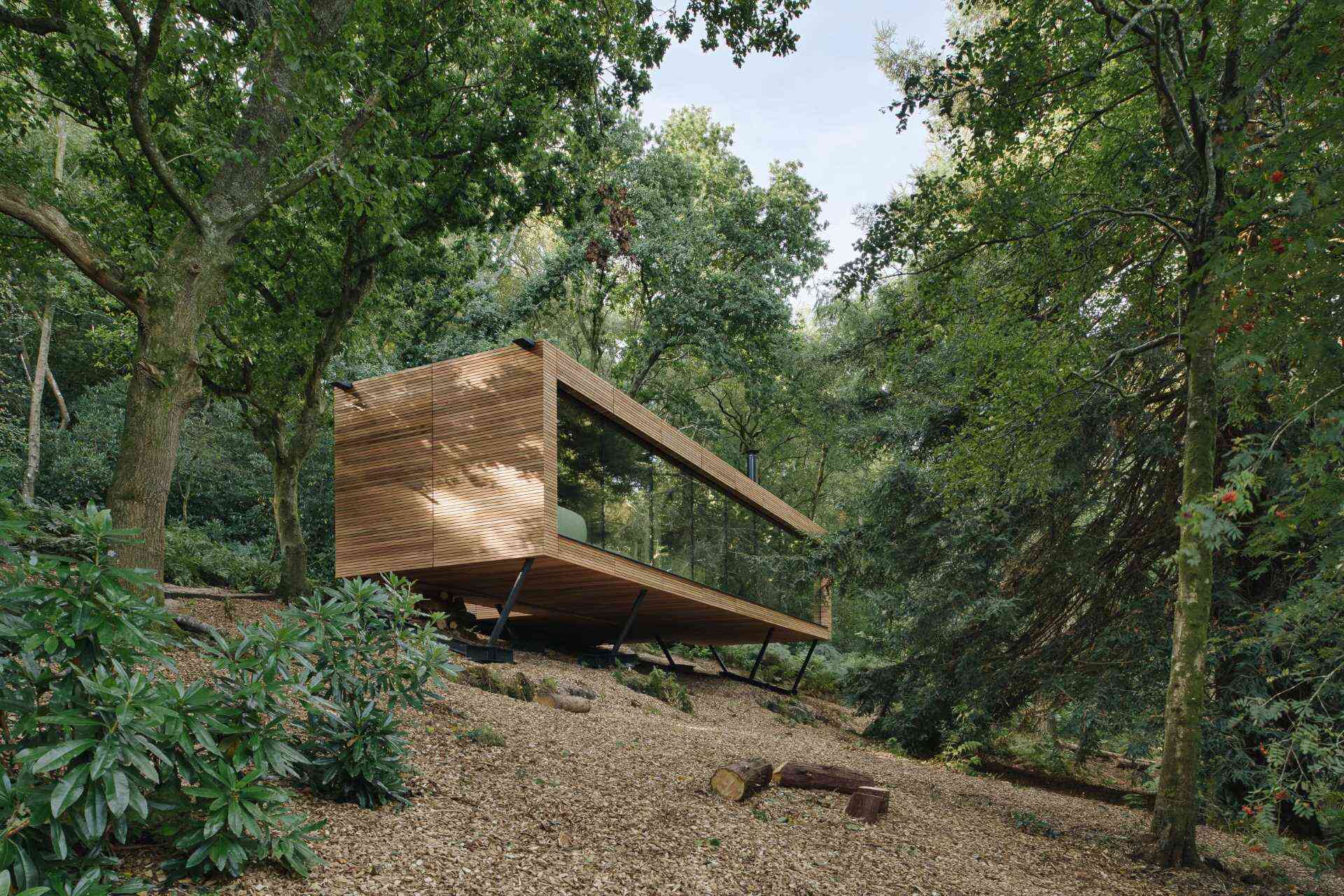 Hidden among the protected woodland of East Sussex, Looking Glass Lodge by Michael Kendrick Architects blends modern architecture with beautiful forest views. Take a tour inside this unique cedar-clad holiday home.