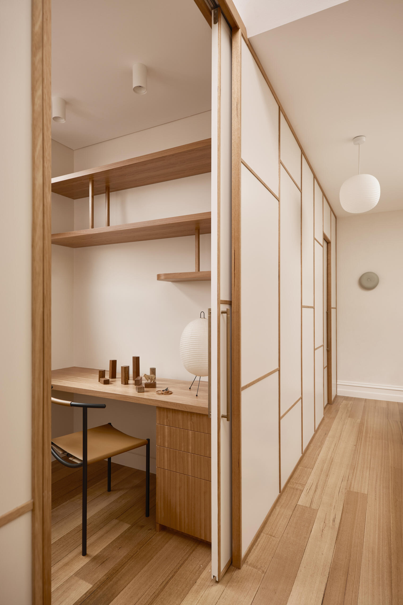 An upstairs hallway with shoji-style partitions concealing a study, blending Japanese influence with Victorian terrace structure.