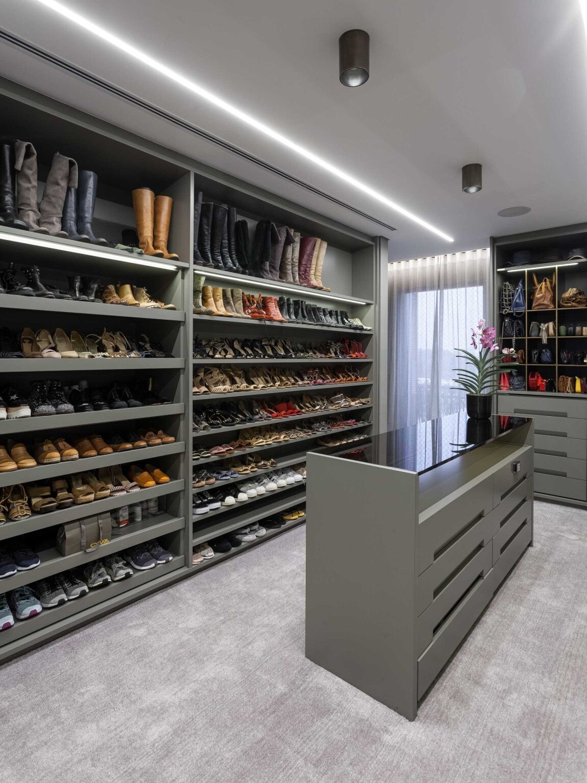 A luxury primary bedroom combines hidden lighting, custom millwork, and spacious walk-in closets to create a sophisticated and highly functional private suite.