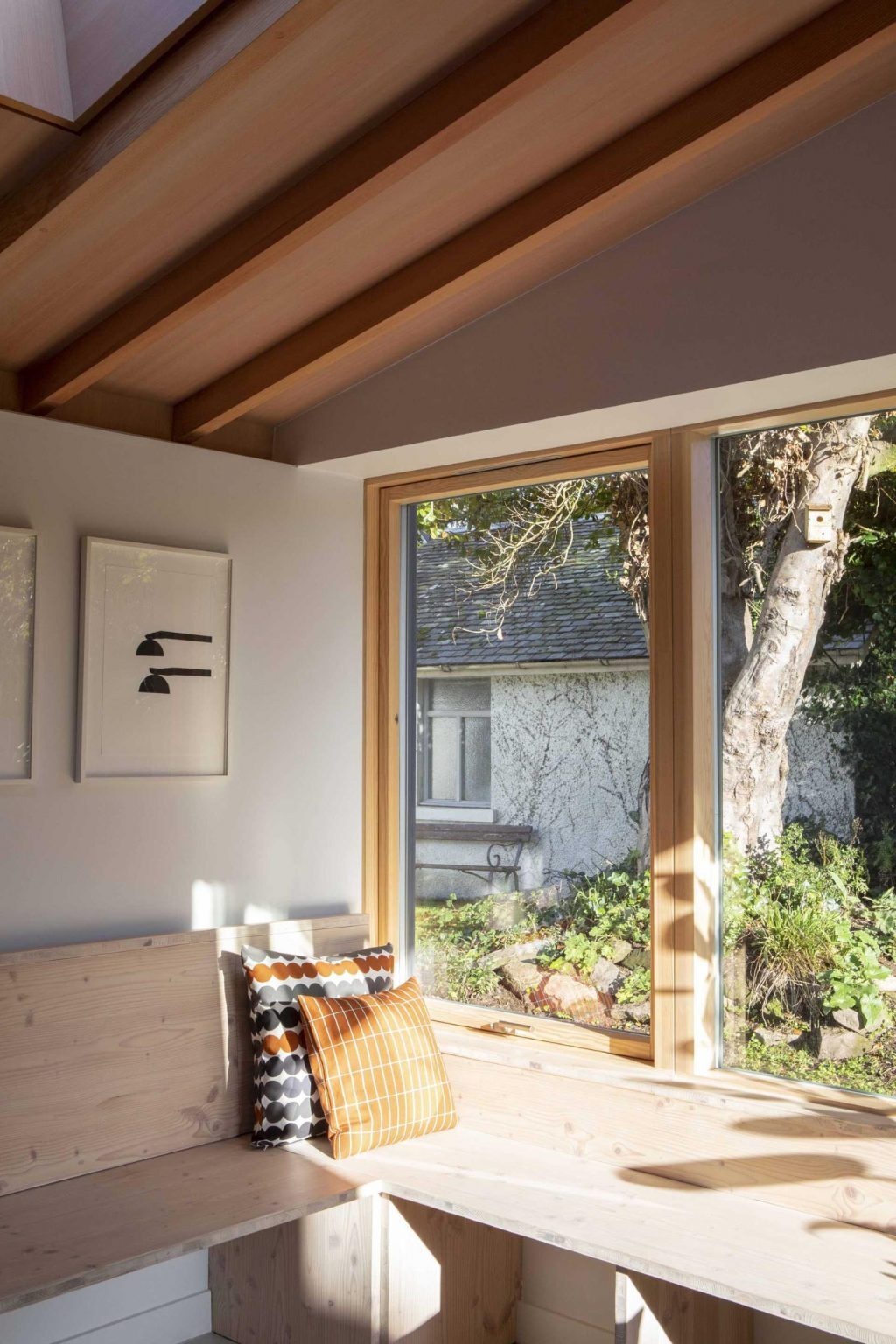 Exposed timber beams, soft white walls, and light micro cement flooring create a warm and contemporary interior palette. Natural materials bring texture and brightness while allowing the architecture and garden views to take centre stage.