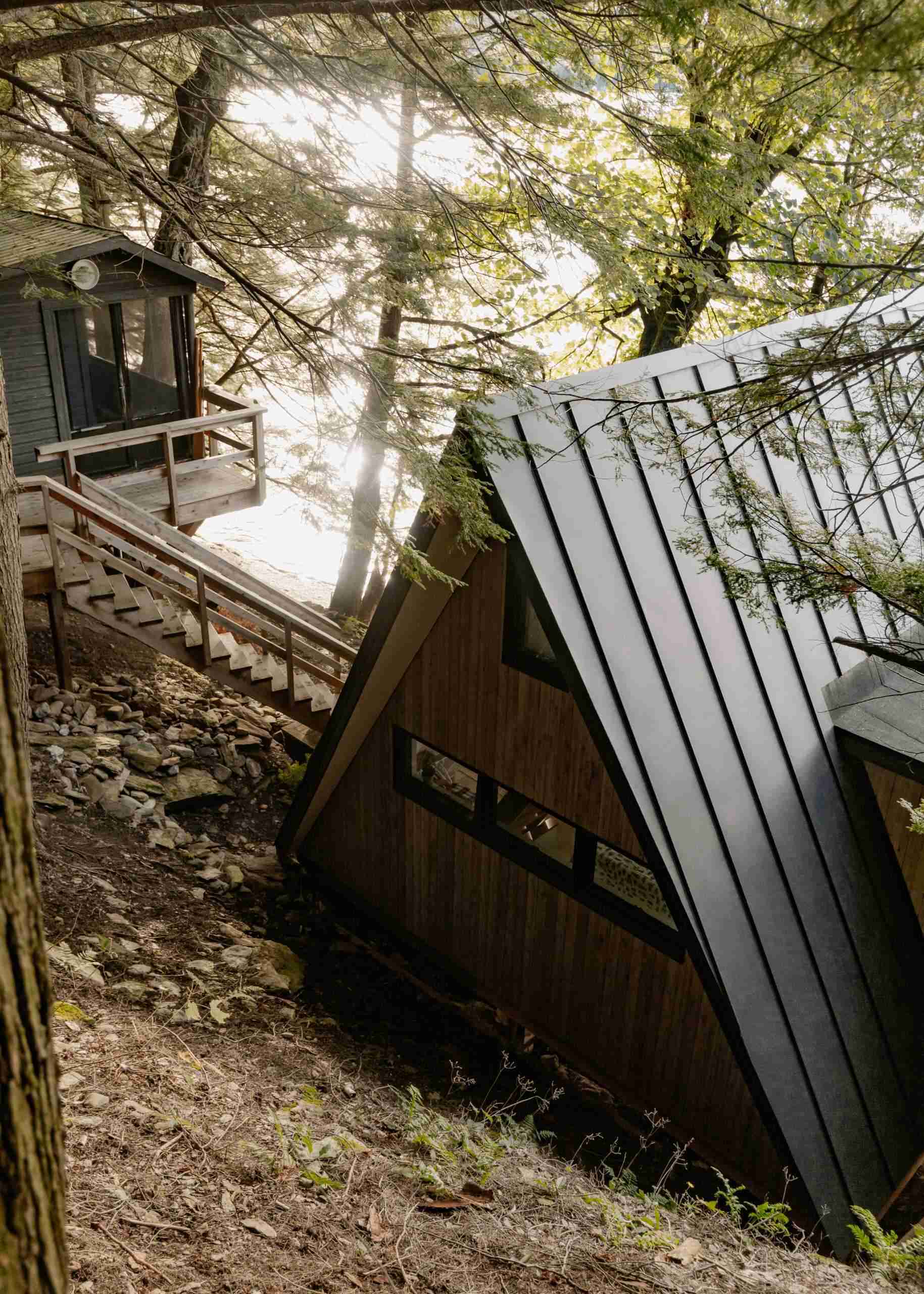 Natural white cedar, metal roofing and modern windows give this classic A-frame cabin a durable new exterior while preserving its iconic shape. A beautiful example of modern cabin renovation.