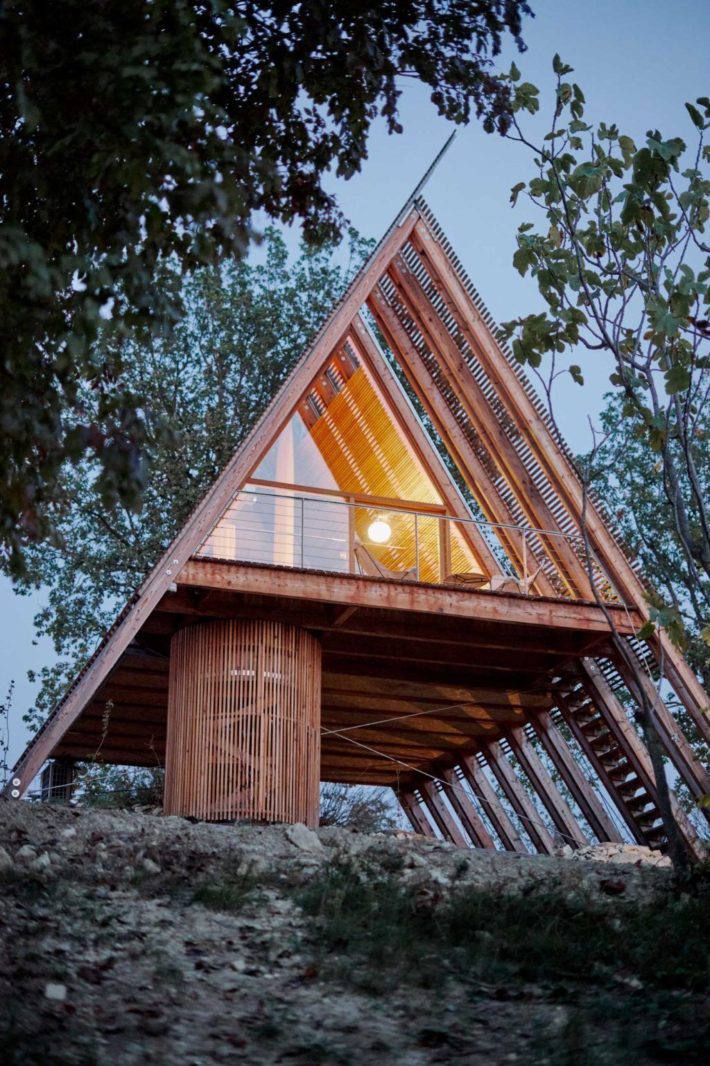 Inspired by traditional haystacks, these contemporary timber cabins combine an A-shaped structure, floor-to-ceiling glazing, and prefabricated construction to create a striking eco-hotel in Italy.