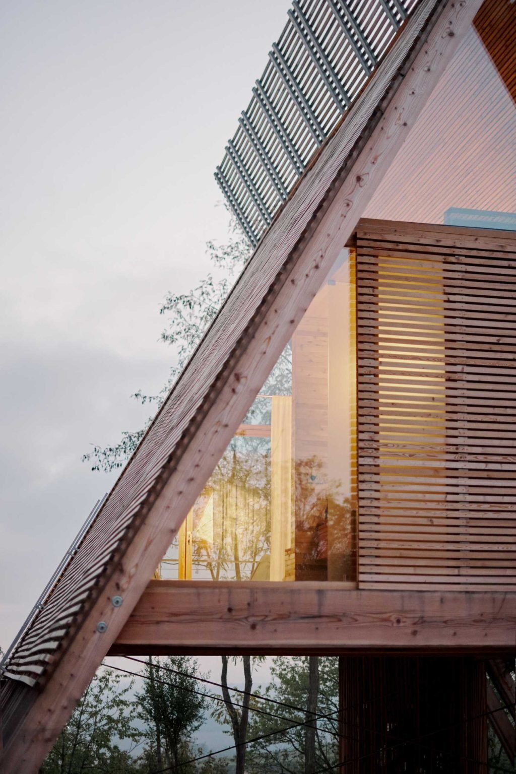 Inspired by traditional haystacks, these contemporary timber cabins combine an A-shaped structure, floor-to-ceiling glazing, and prefabricated construction to create a striking eco-hotel in Italy.