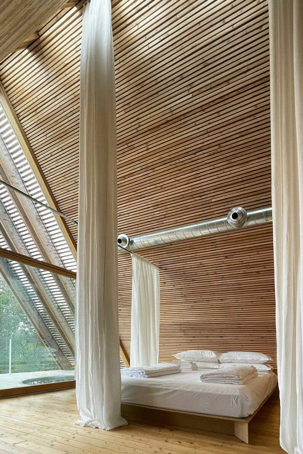 Floor-to-ceiling curtains offer a simple way to create privacy while preserving the open feel of these minimalist timber cabins.