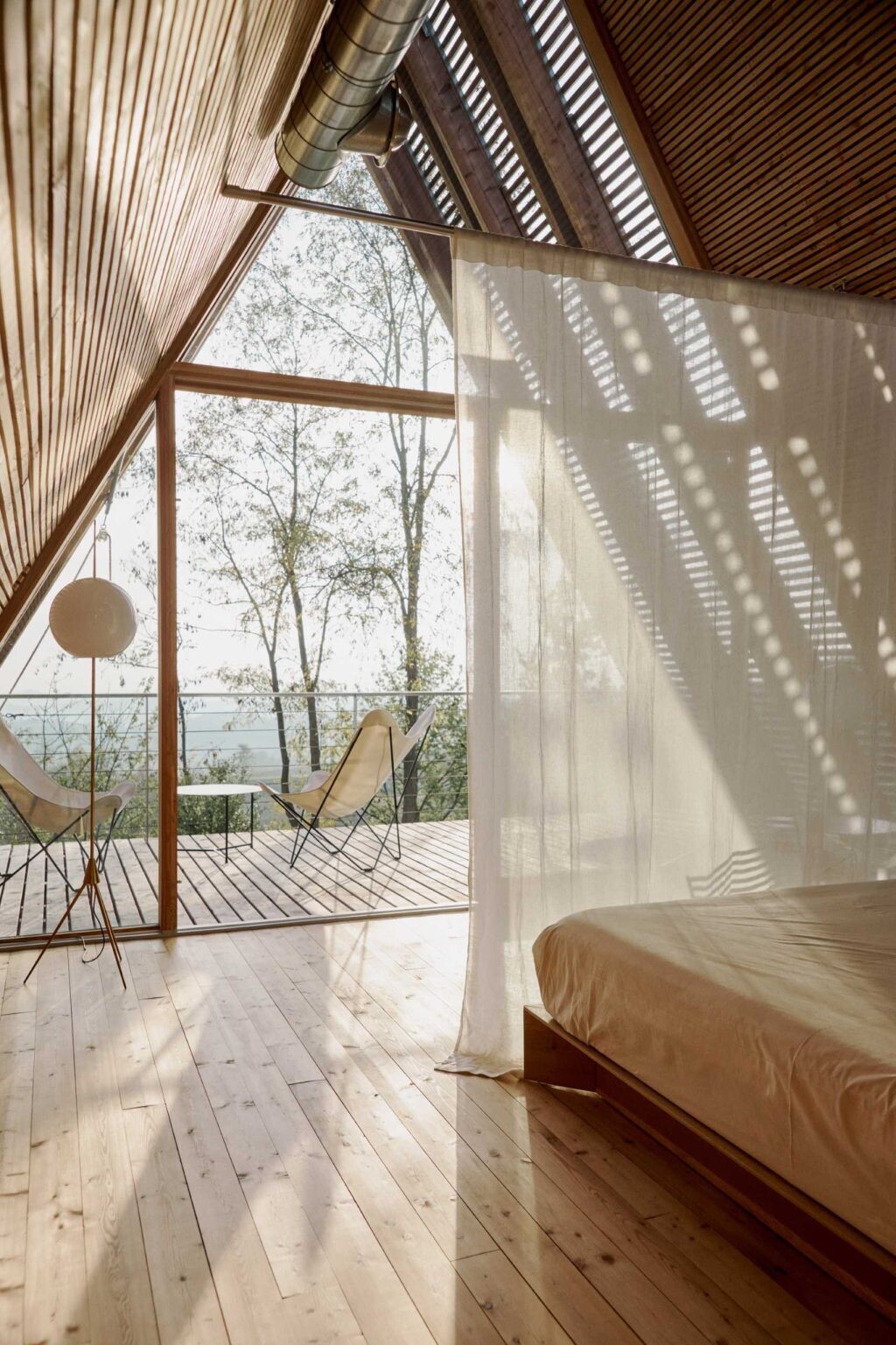 Floor-to-ceiling curtains offer a simple way to create privacy while preserving the open feel of these minimalist timber cabins.