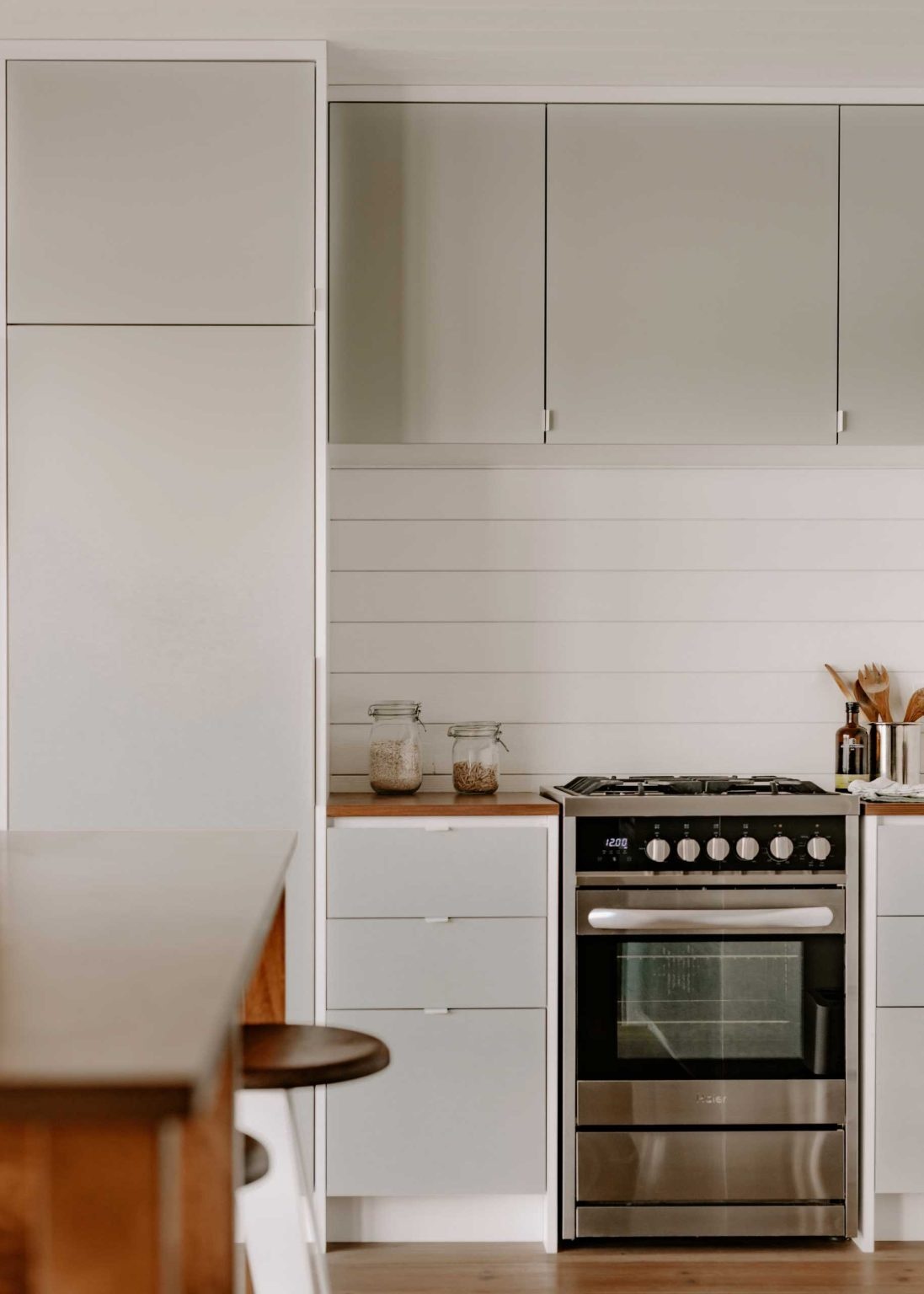 Minimalist cabinetry and a warm timber island give this compact kitchen a clean, inviting look while making every inch of space work harder.