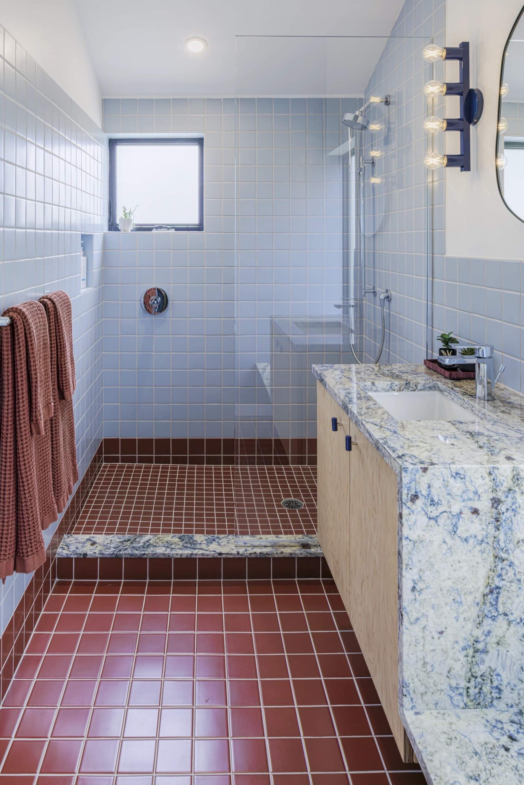 Colourful tile and a unique stone vanity give this compact bathroom plenty of character.