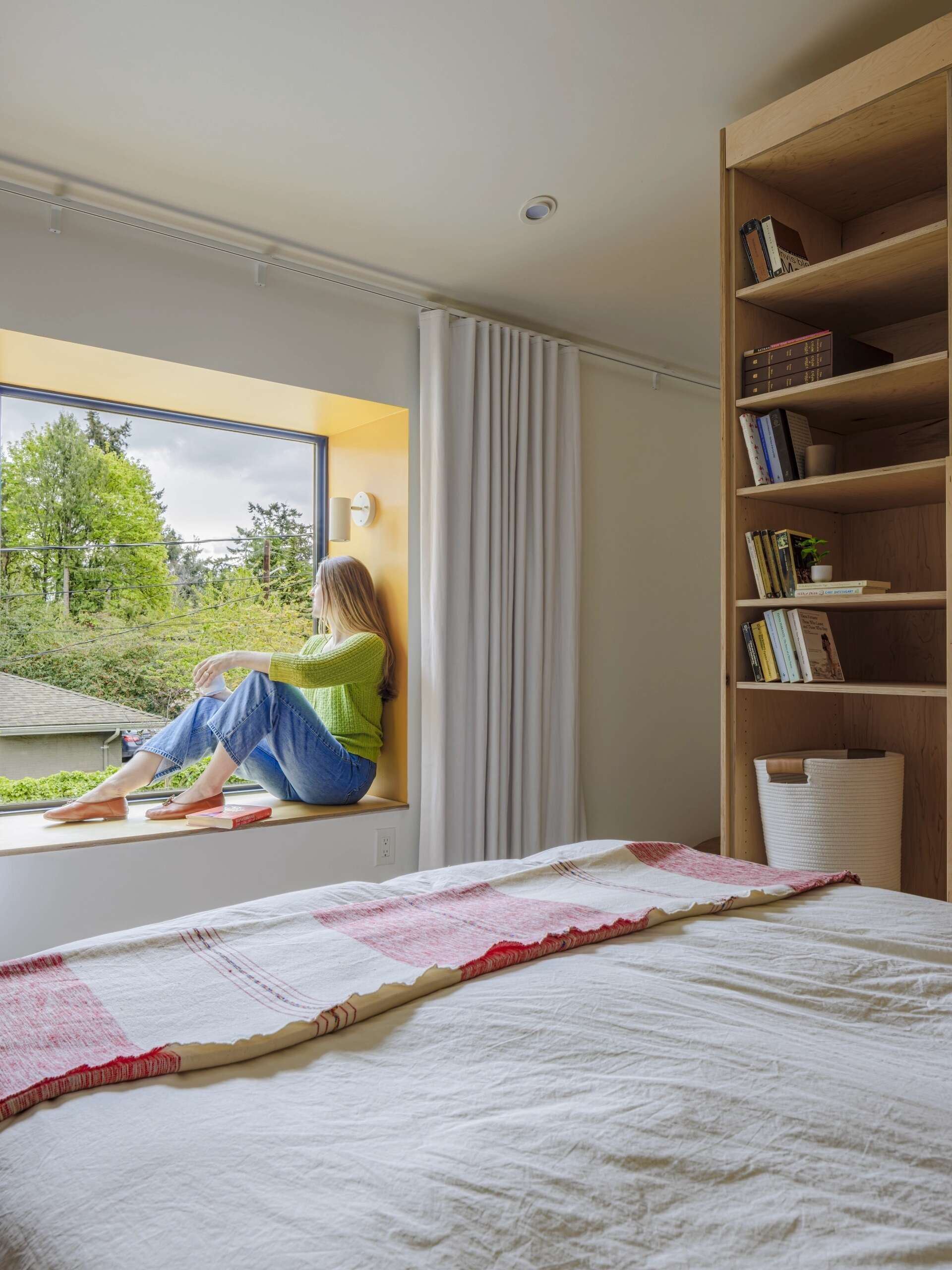 A hidden bedroom and sunny window seat show how custom cabinetry can completely transform a small home.
