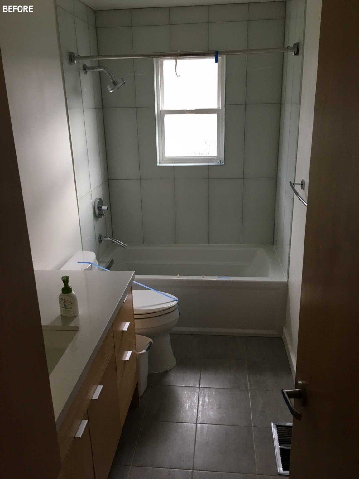 BEFORE - This updated bathroom combine warm wood details, full-height subway tiles, and abundant natural light to create clean, contemporary spaces.