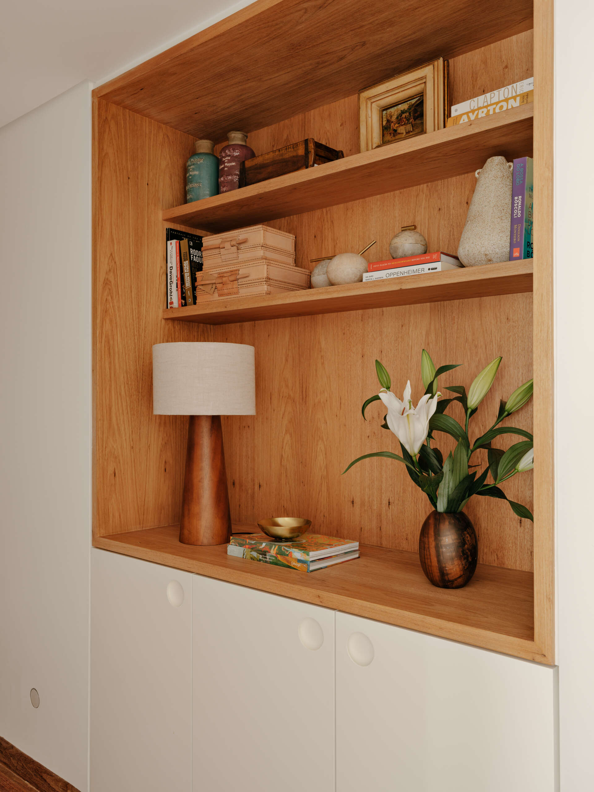 Custom wardrobes with illuminated timber niches turn a simple hallway into a beautiful design feature.