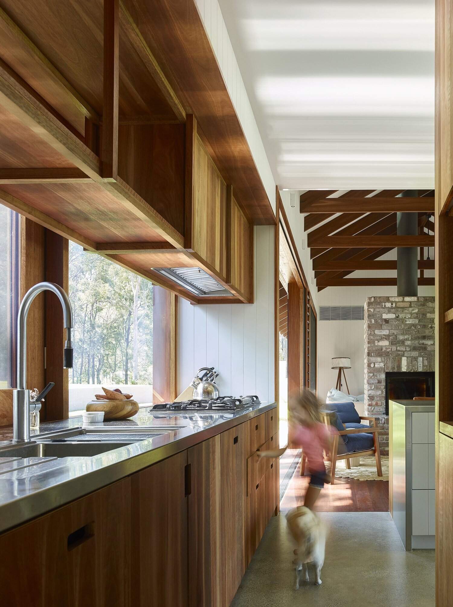 This timber kitchen replaces a traditional backsplash with large windows overlooking the Australian bush.