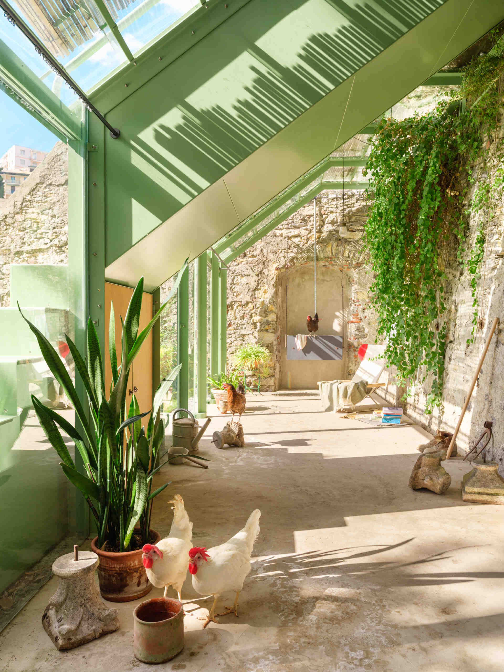 See how a transparent greenhouse filled with natural light creates a seamless visual connection with the surrounding garden.