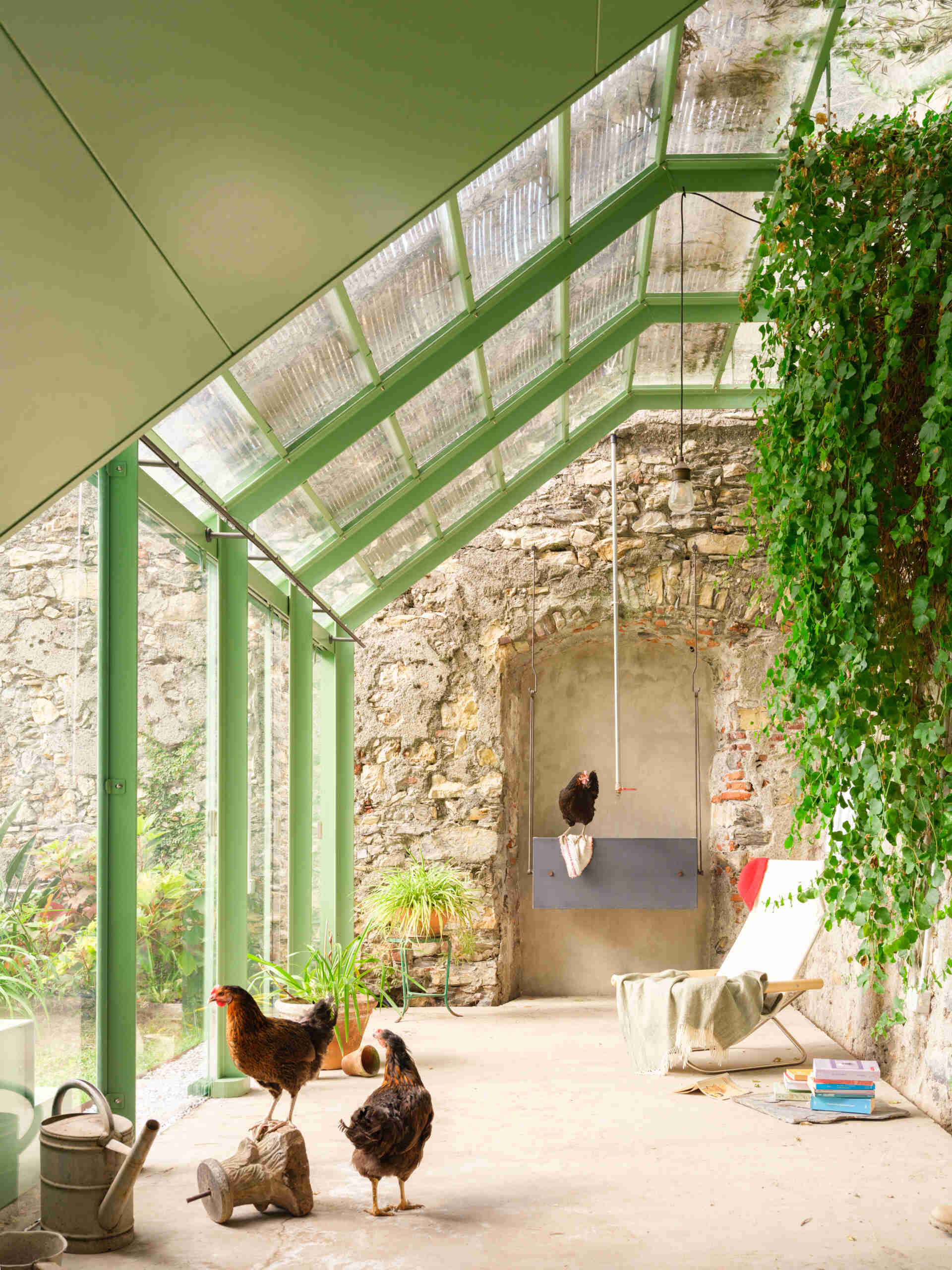 See how a transparent greenhouse filled with natural light creates a seamless visual connection with the surrounding garden.