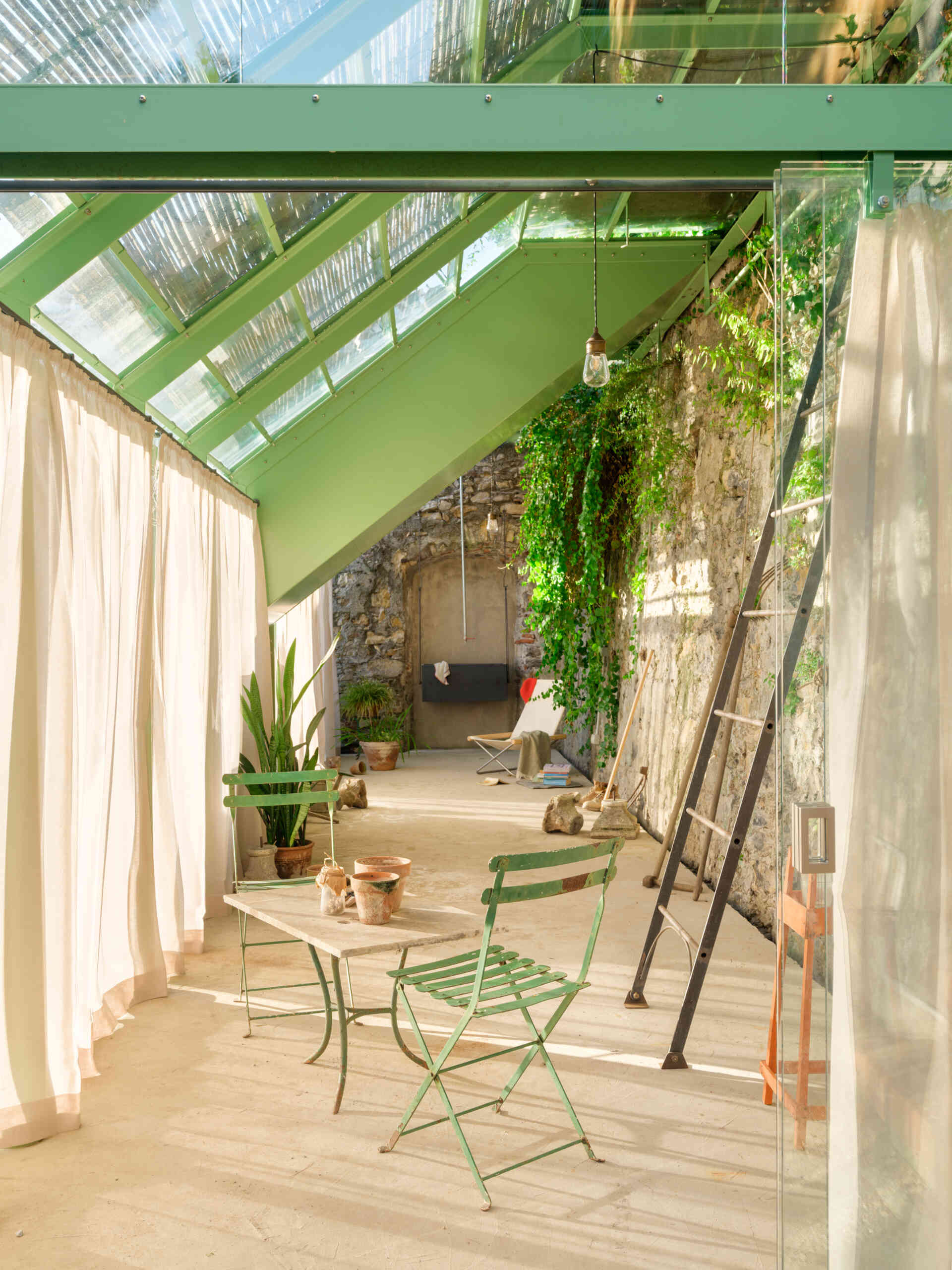 Historic masonry, slim steel framing, and glass come together in this elegant garden project that blends contemporary architecture with an existing landscape.