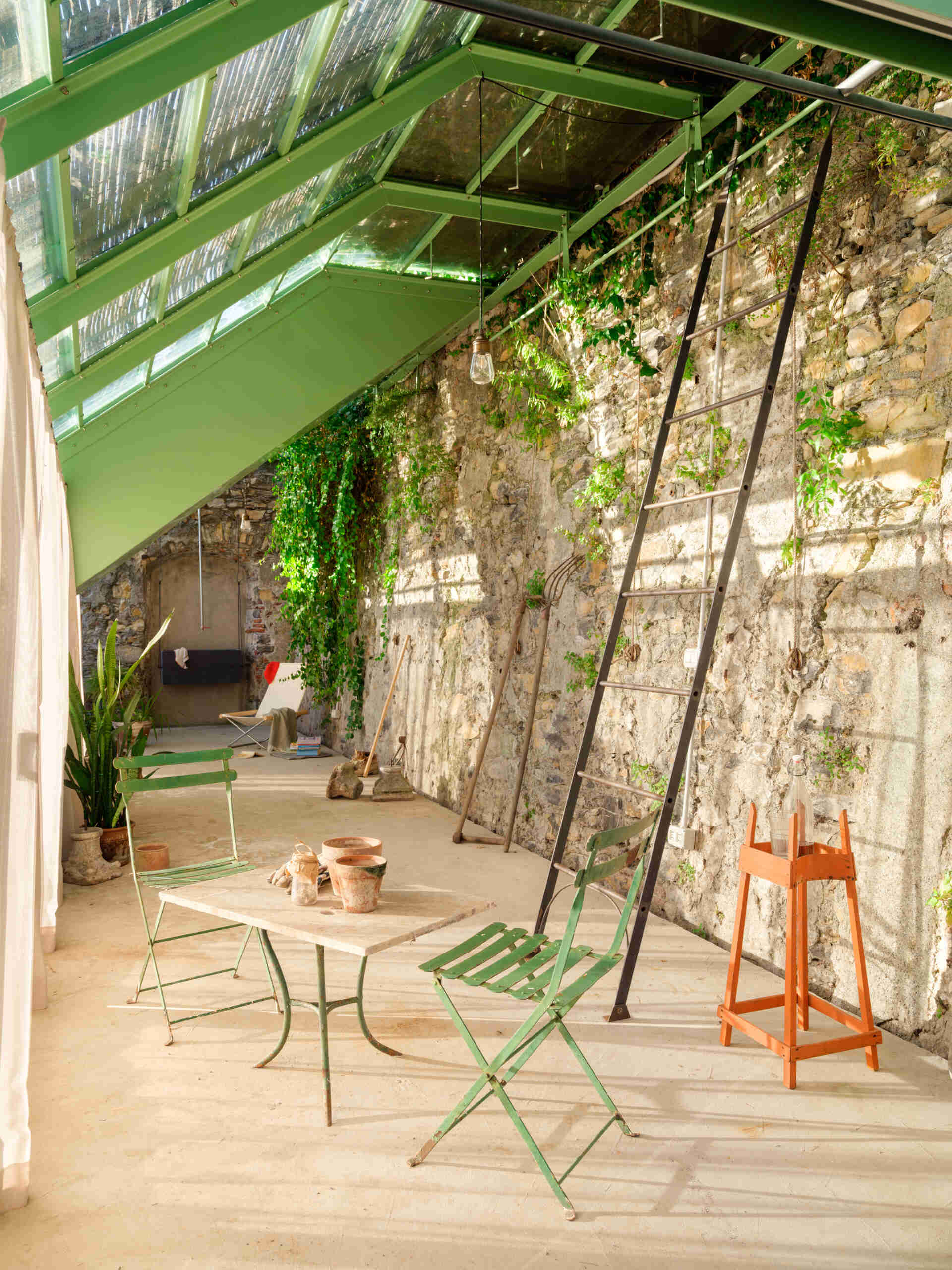 Historic masonry, slim steel framing, and glass come together in this elegant garden project that blends contemporary architecture with an existing landscape.