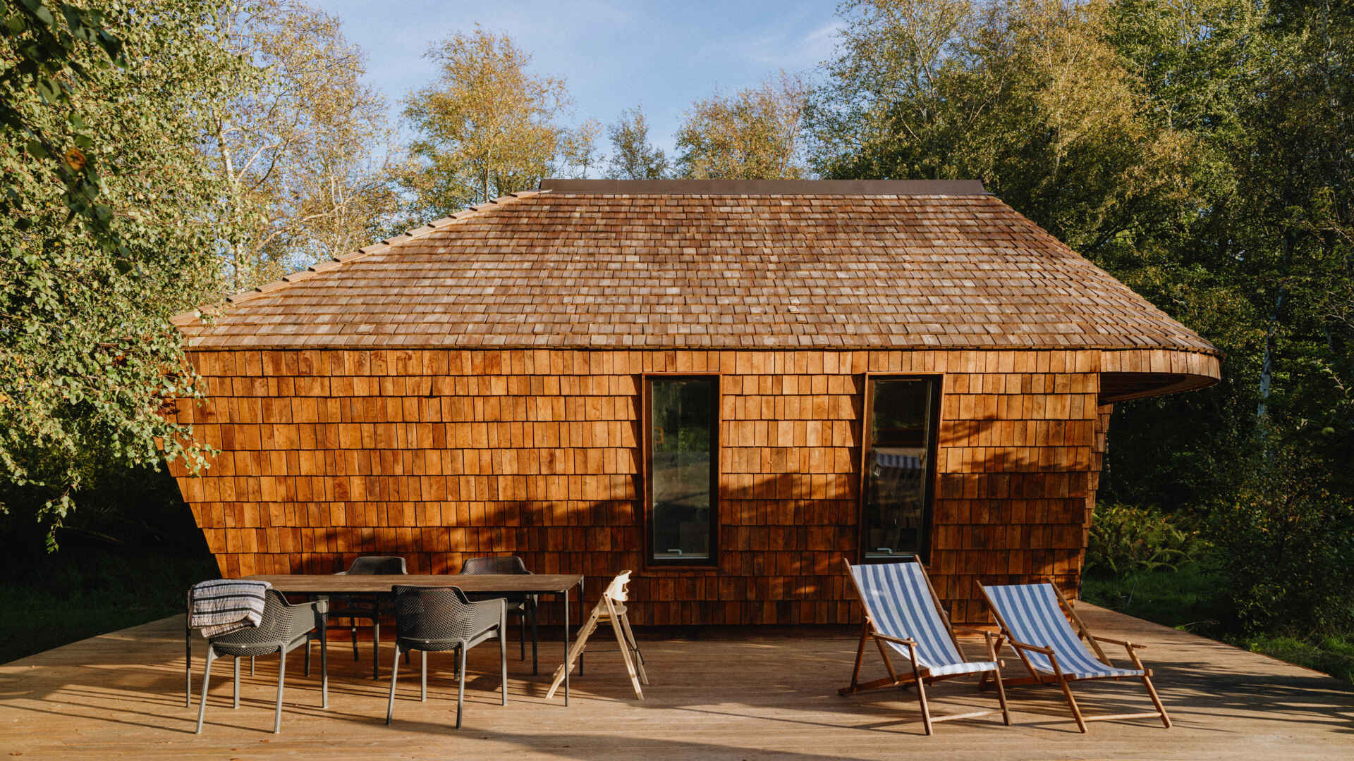 Natural timber, digital fabrication, and a low-carbon approach shape a garden house's warm exterior and efficient construction.