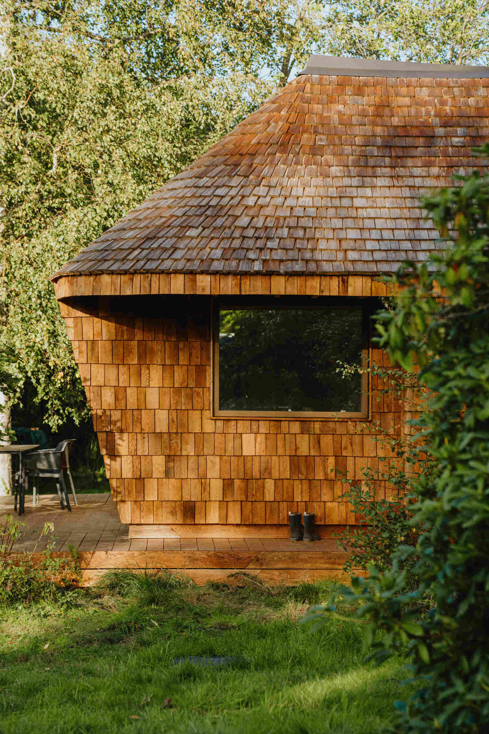 Natural timber, digital fabrication, and a low-carbon approach shape a garden house's warm exterior and efficient construction.