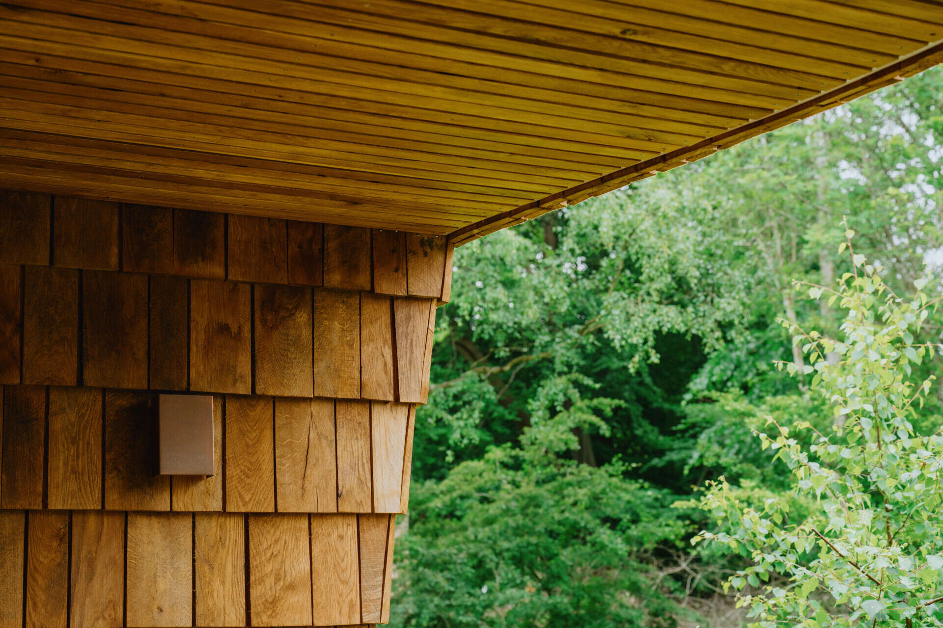 Natural timber, digital fabrication, and a low-carbon approach shape a garden house's warm exterior and efficient construction.