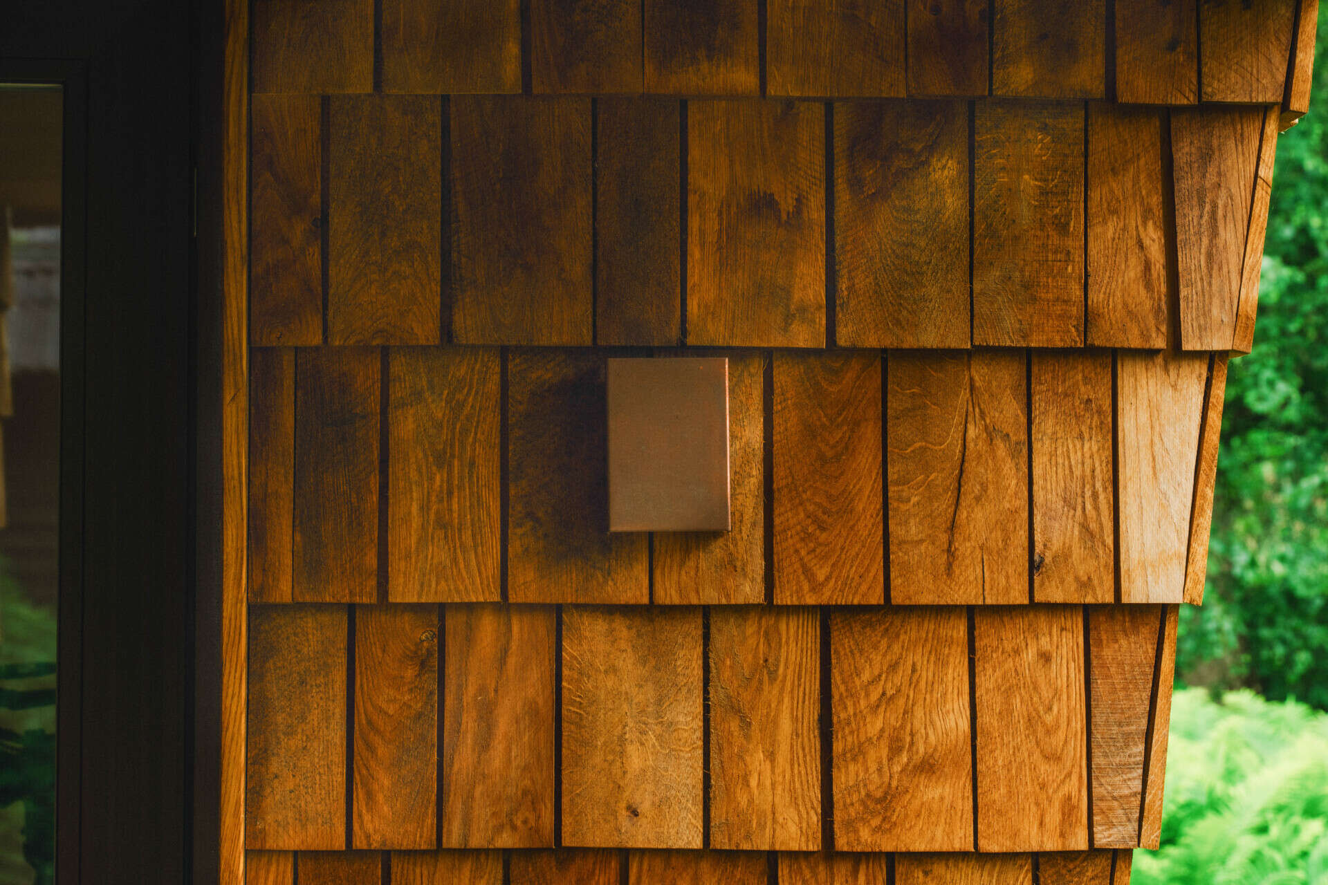Natural timber, digital fabrication, and a low-carbon approach shape a garden house's warm exterior and efficient construction.