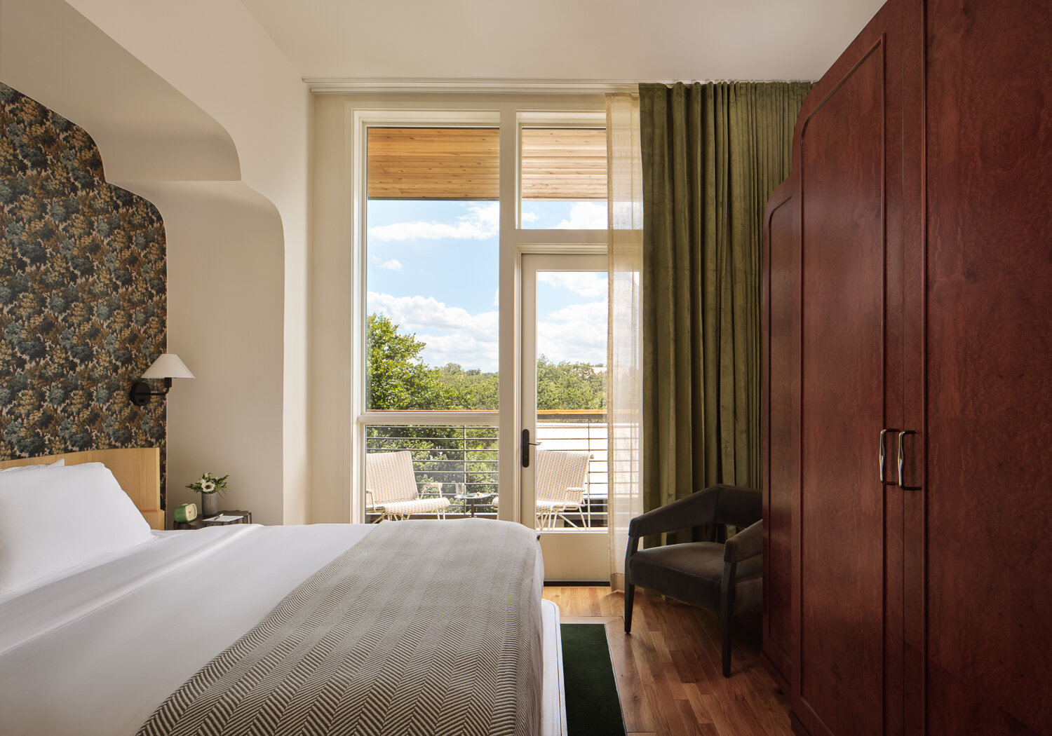 Forest greens, floral wallpaper, white oak millwork and elegant finishes give this boutique hotel a welcoming character.