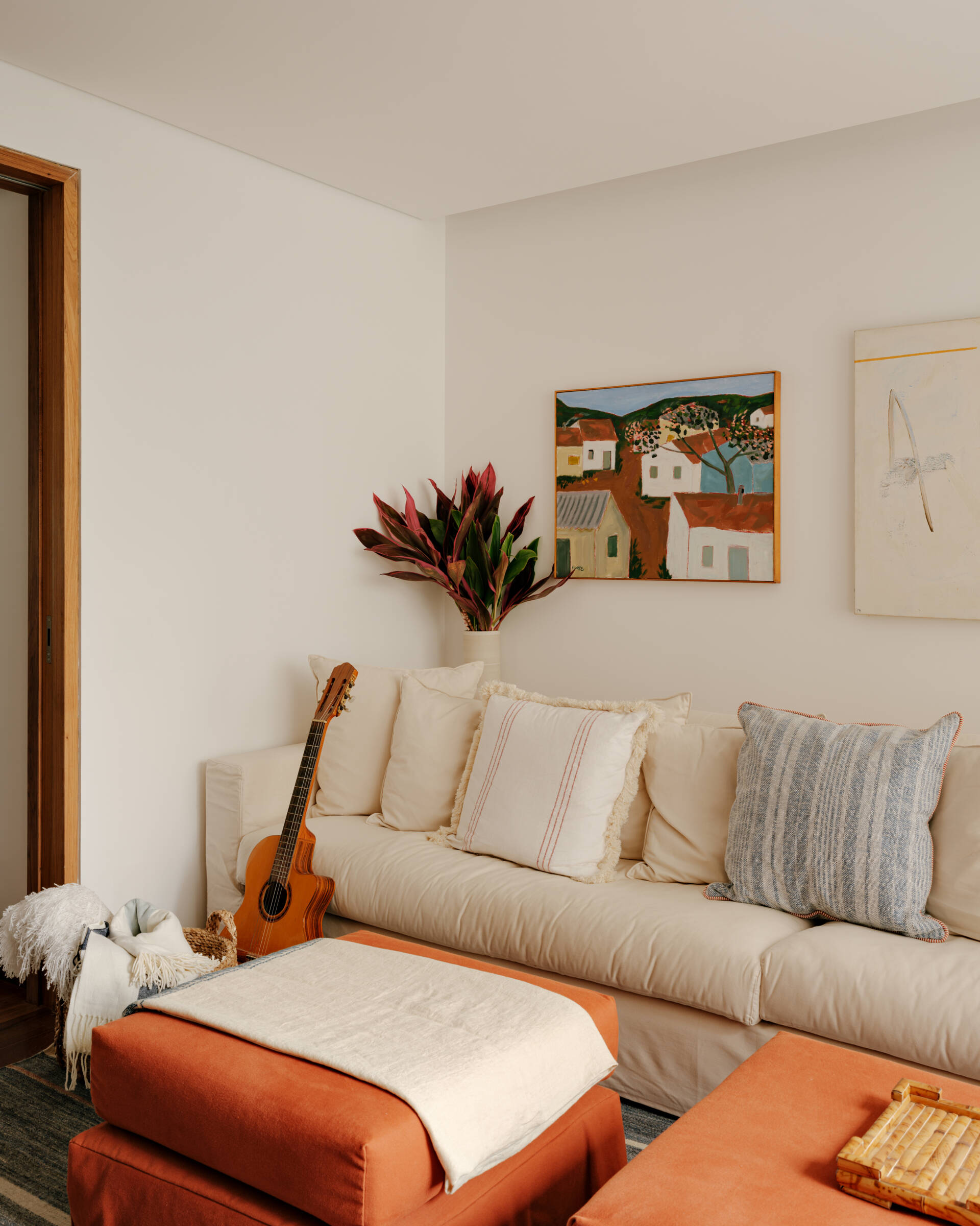 A cosy media room shows how custom shelving, artwork and warm colours can make a TV space feel more inviting.