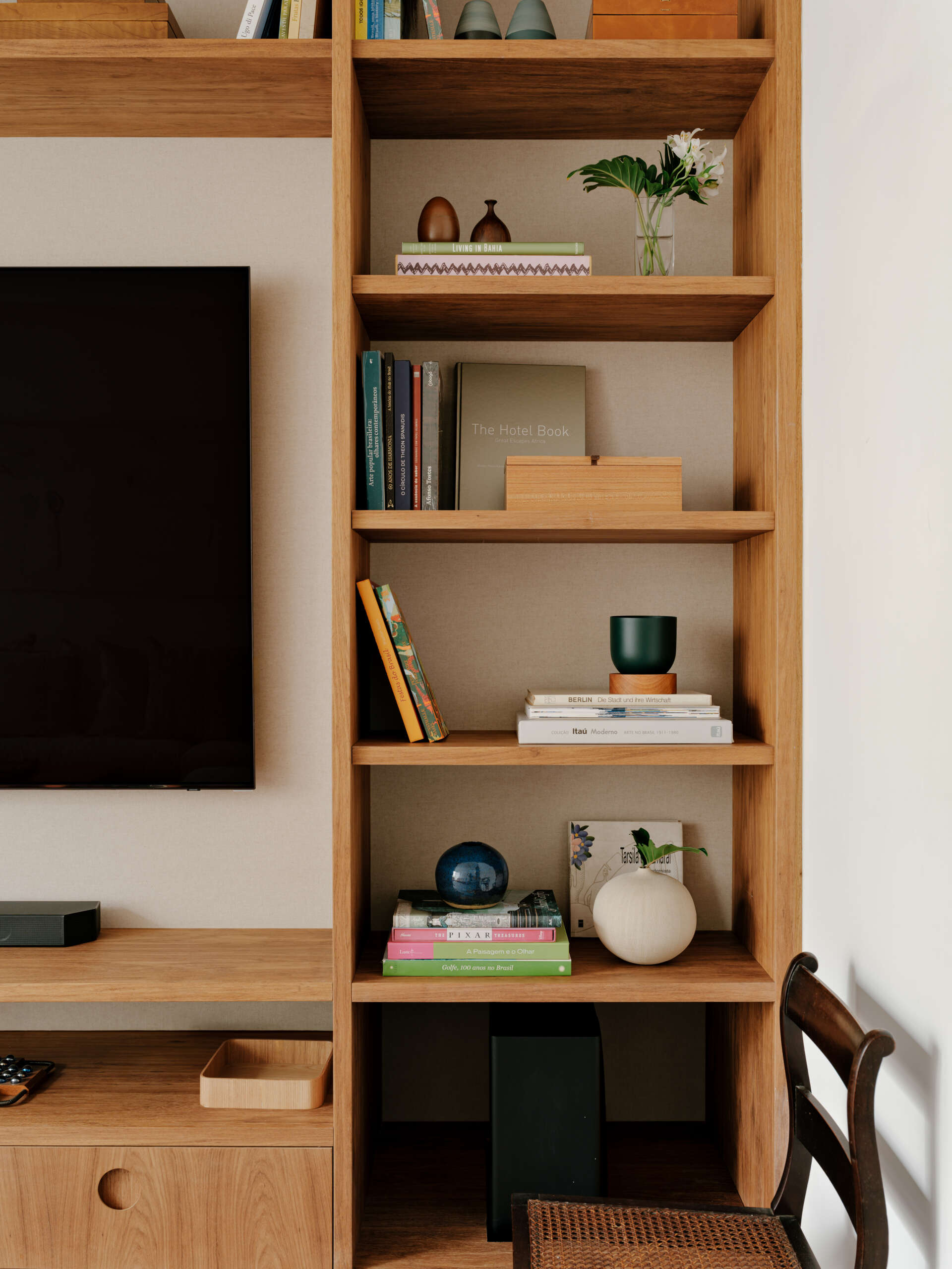 A cosy media room shows how custom shelving, artwork and warm colours can make a TV space feel more inviting.