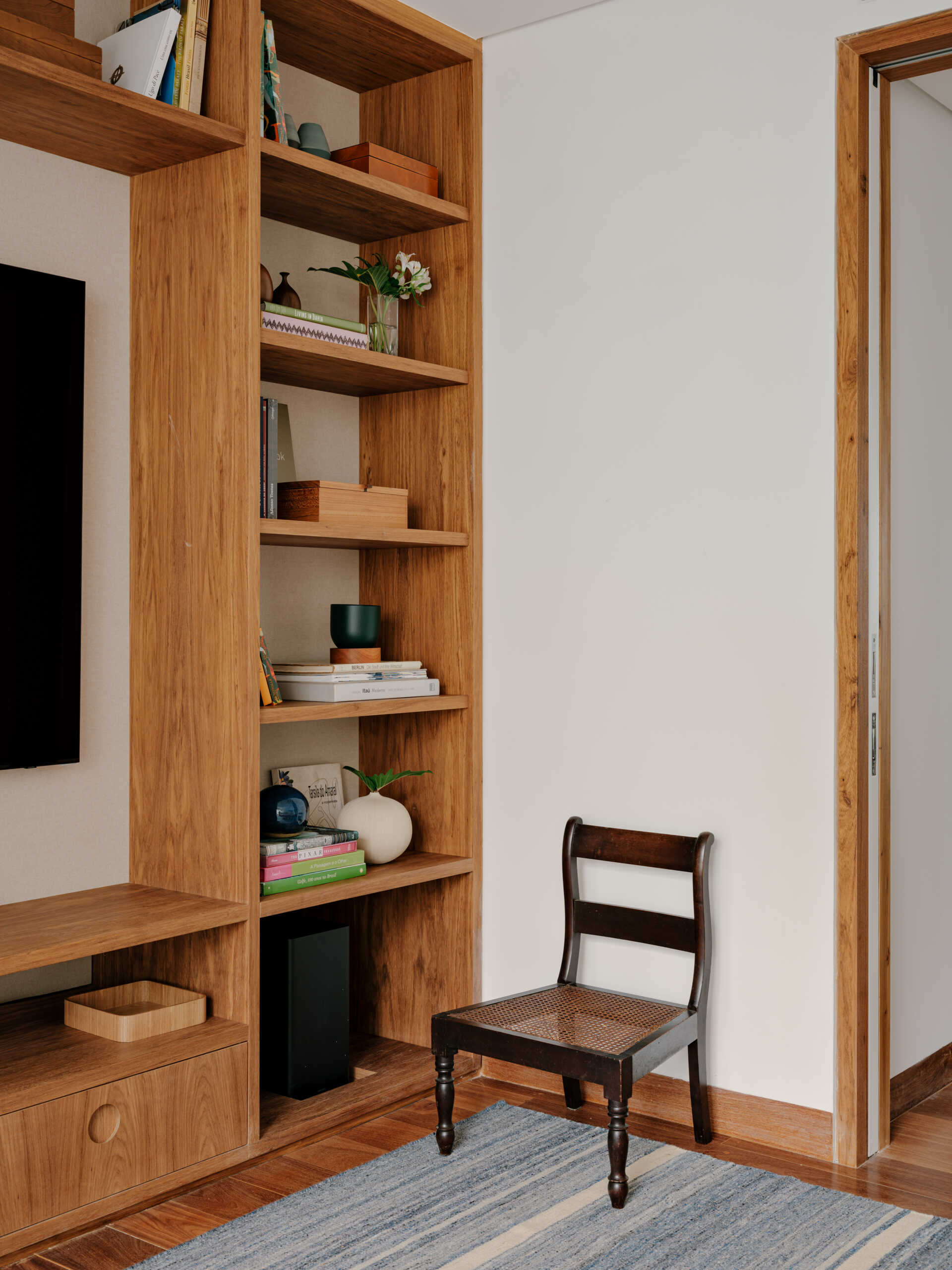 A cosy media room shows how custom shelving, artwork and warm colours can make a TV space feel more inviting.