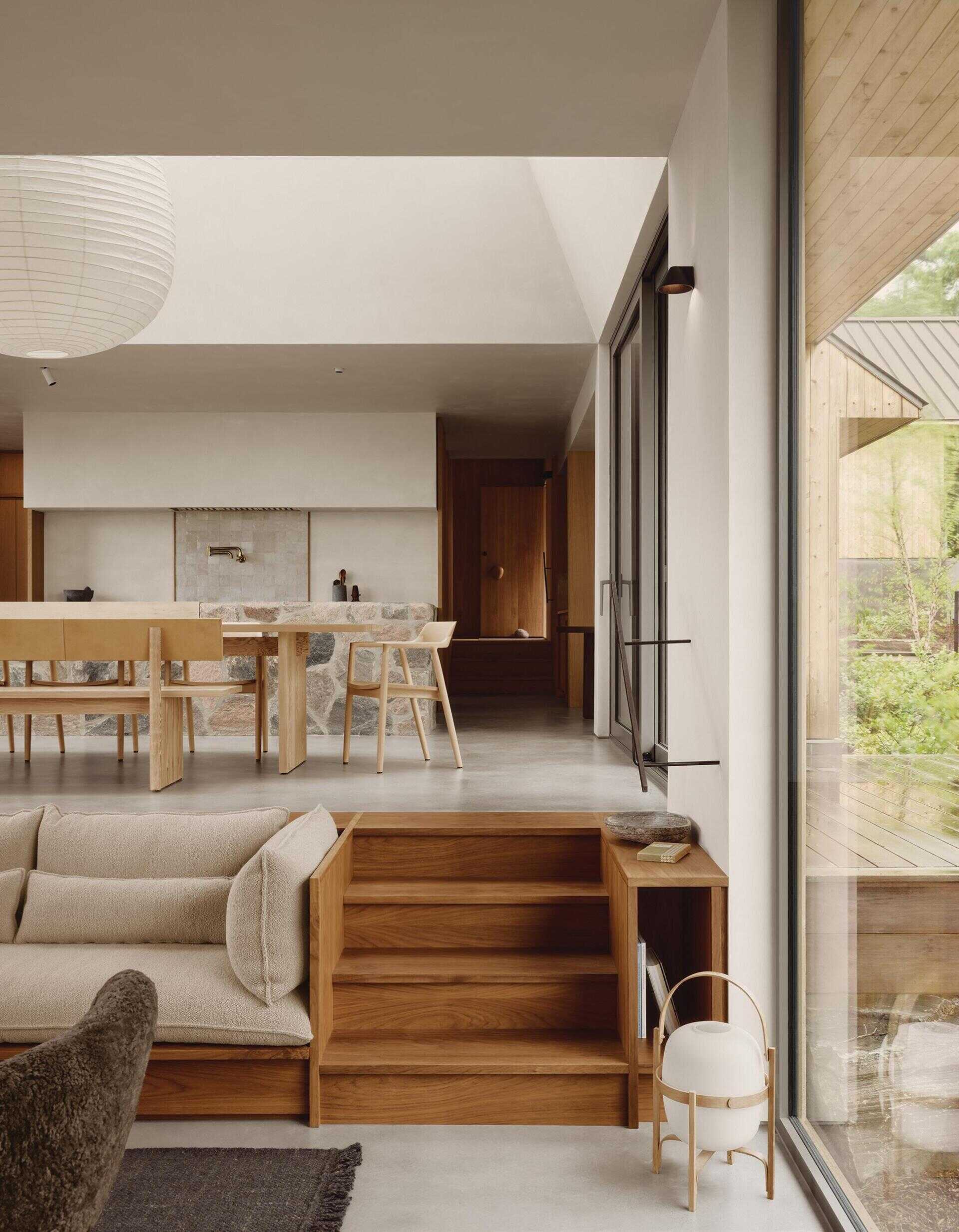 Discover how subtle level changes create a beautiful flow between the living room and dining area in this Canadian island cottage.
