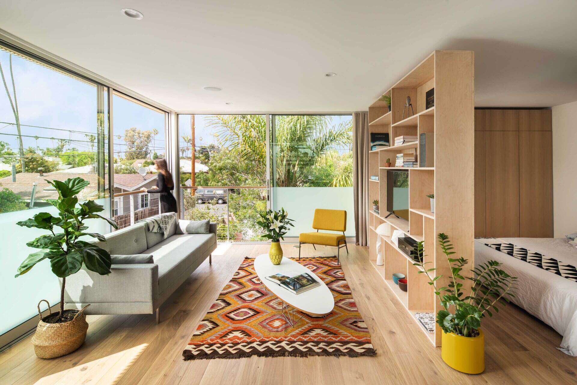 Tour this clever studio apartment where one open room includes a full kitchen, living space, bedroom, and bathroom without feeling cramped.