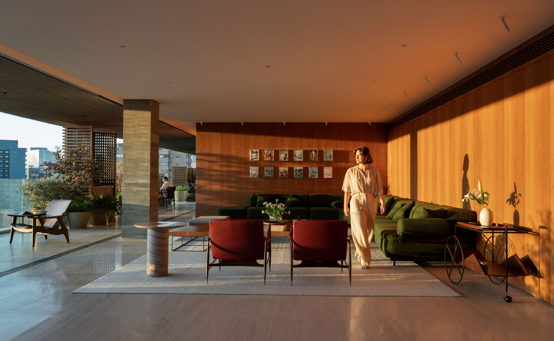 This living room combines iconic Brazilian furniture, limestone floors and expansive city views for a warm, inviting entertaining space.