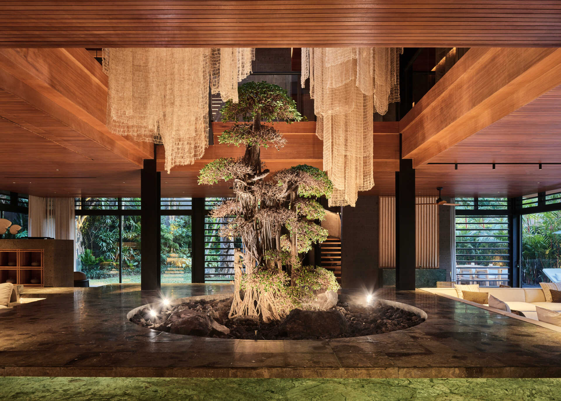 A bonsai tree beneath a skylight creates a peaceful indoor courtyard at the centre of Villa Suki.