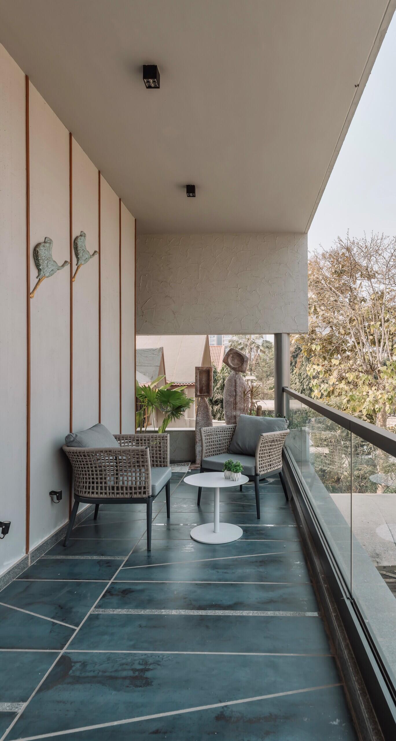 A jharokha-inspired deck, full-height glazing and layered architecture make this balcony feel like an outdoor living room.
