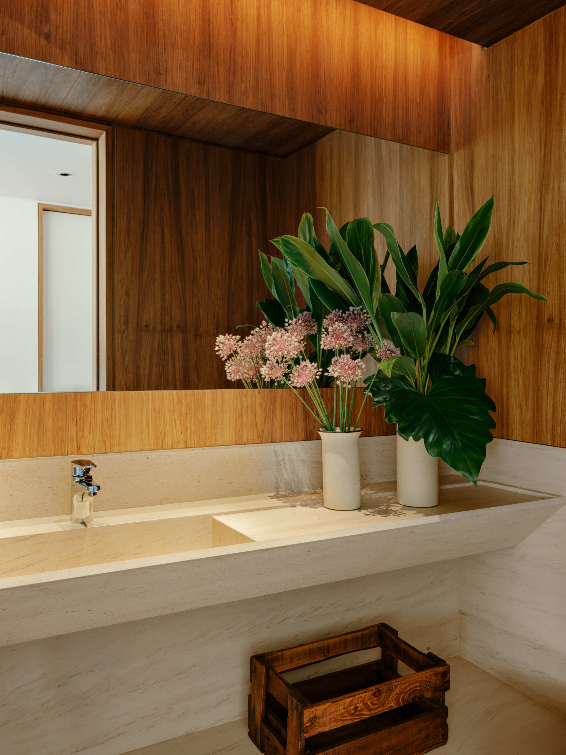 Limestone, timber panelling and concealed lighting give this powder room a timeless contemporary look.