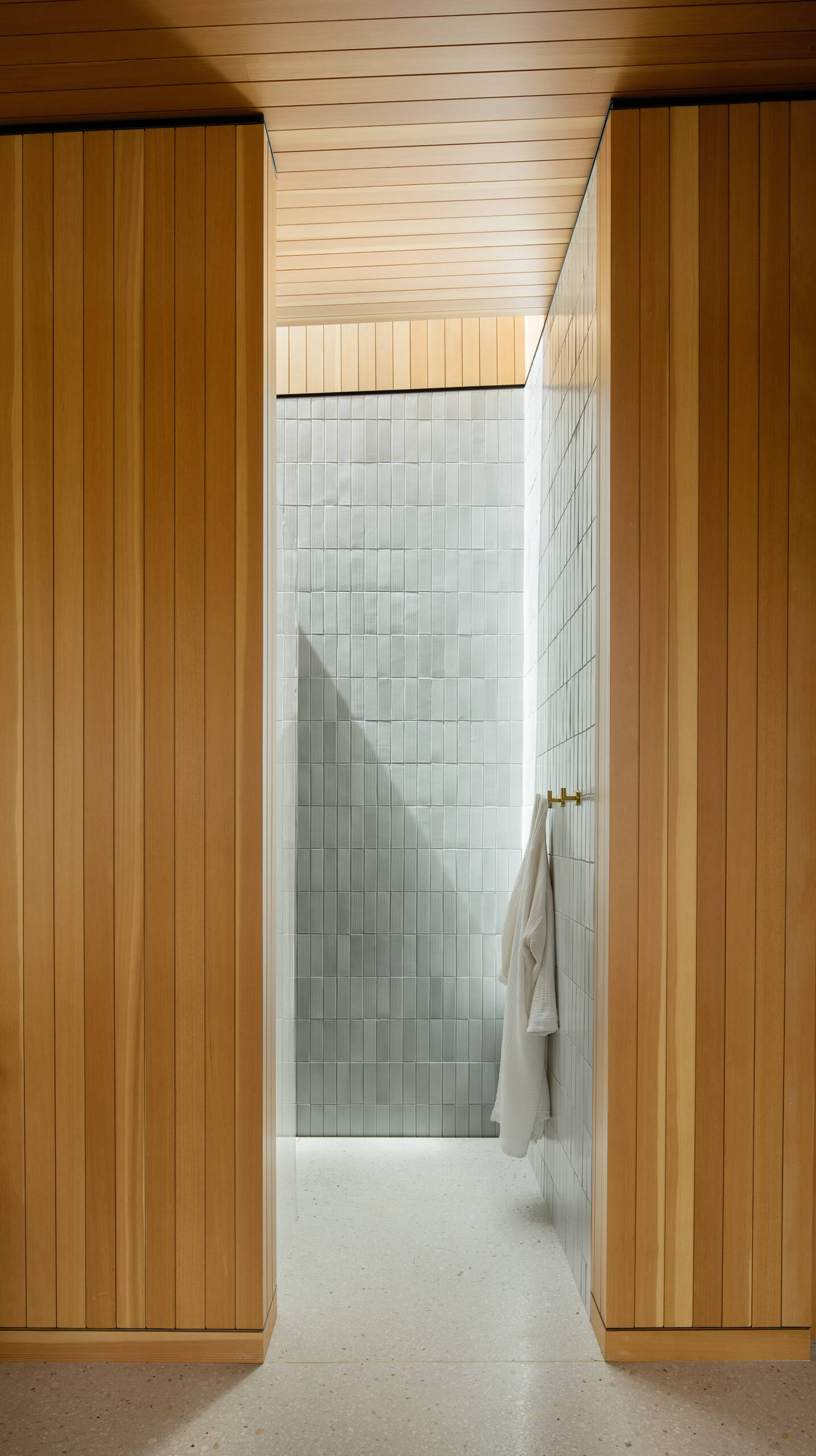 El baño de visitas combina maderas cálidas, azulejos texturizados, accesorios de latón y una hermosa luz natural para crear una apariencia fresca y moderna.
