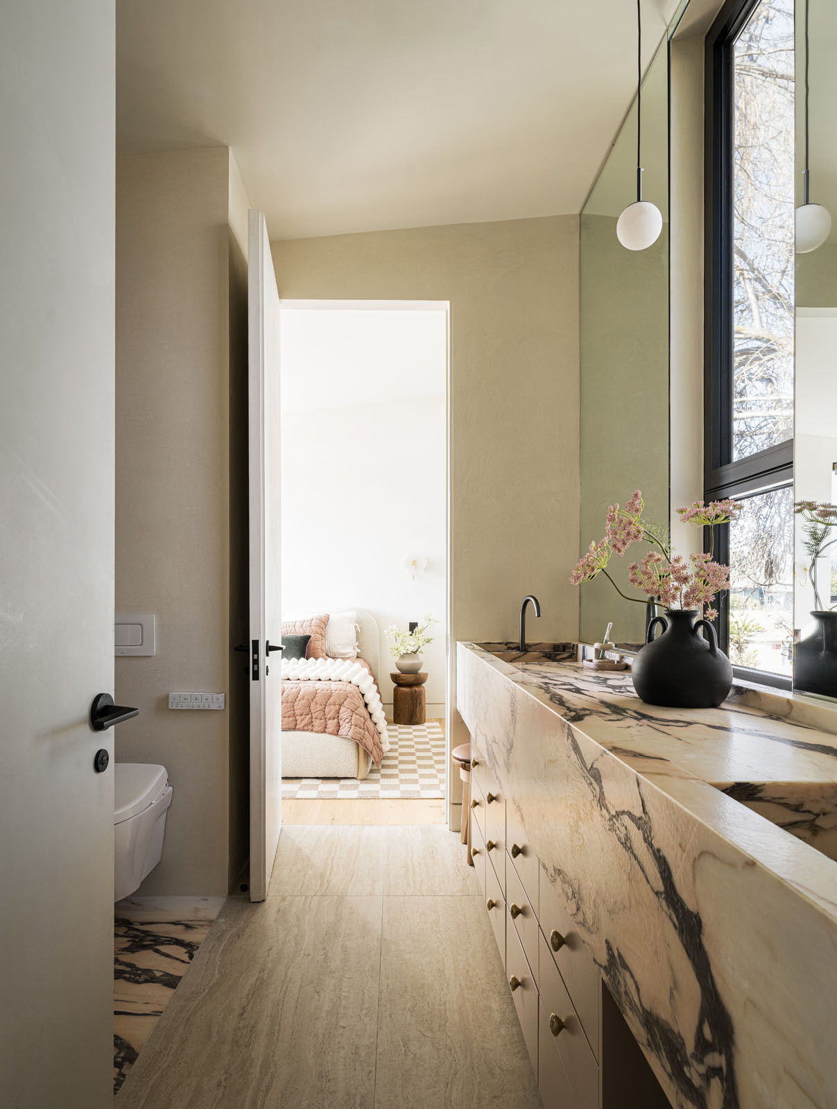 A playful bathroom finished with pink Portuguese marble adds a fun surprise inside this warm and modern Silicon Valley home.