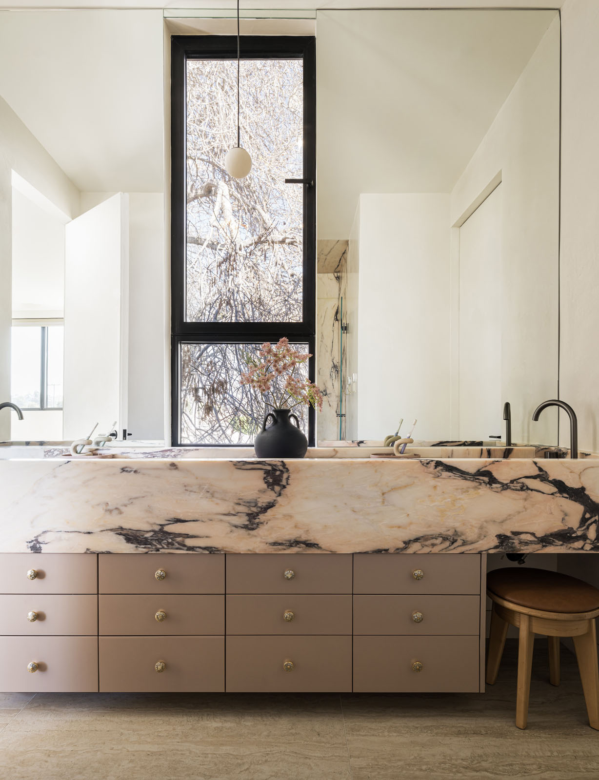 A playful bathroom finished with pink Portuguese marble adds a fun surprise inside this warm and modern Silicon Valley home.