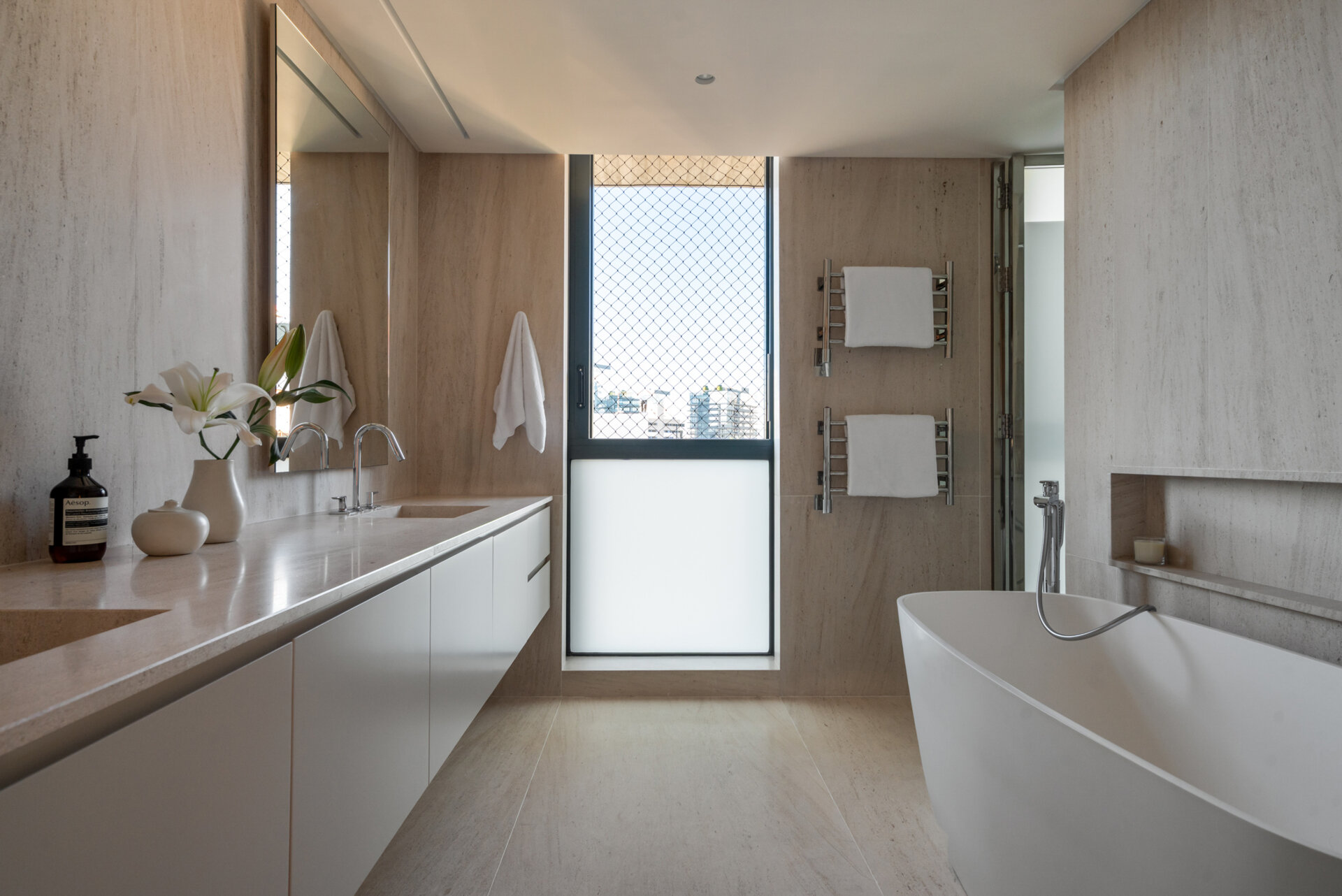 Twin walk-in closets and stone bathrooms create a spacious, organised primary suite with timeless finishes.
