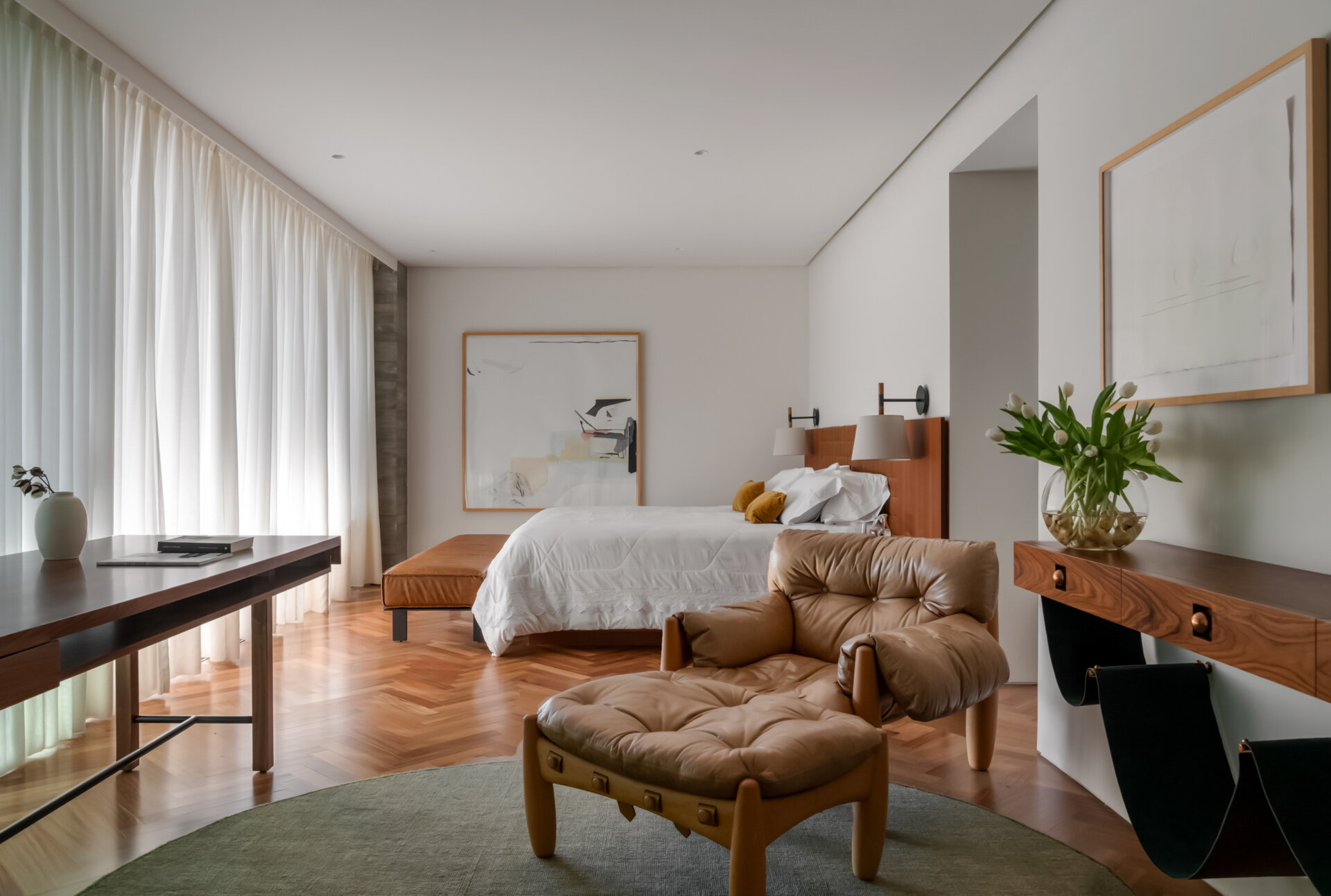 Leather-lined joinery, custom furniture and a private sitting area give this bedroom the feel of a luxury hotel suite.