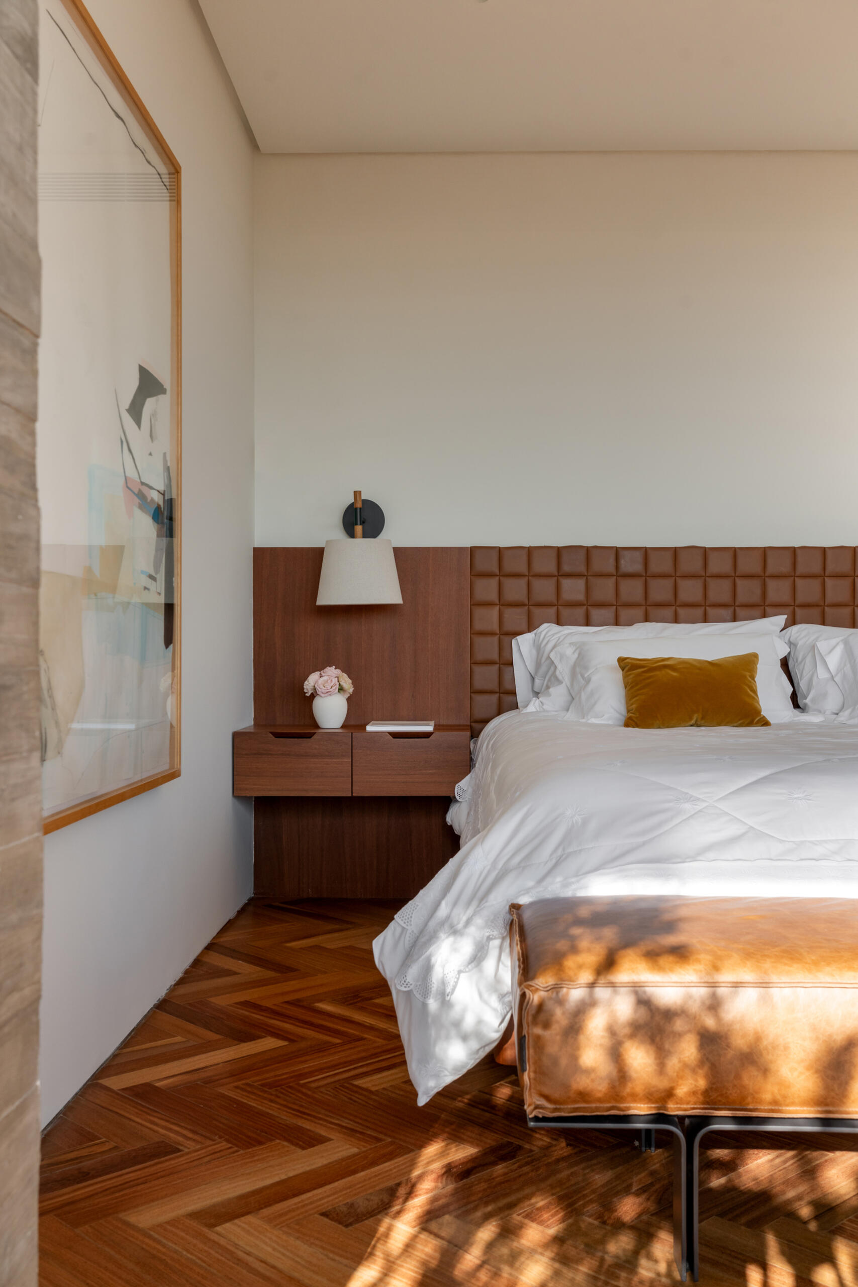 Leather-lined joinery, custom furniture and a private sitting area give this bedroom the feel of a luxury hotel suite.