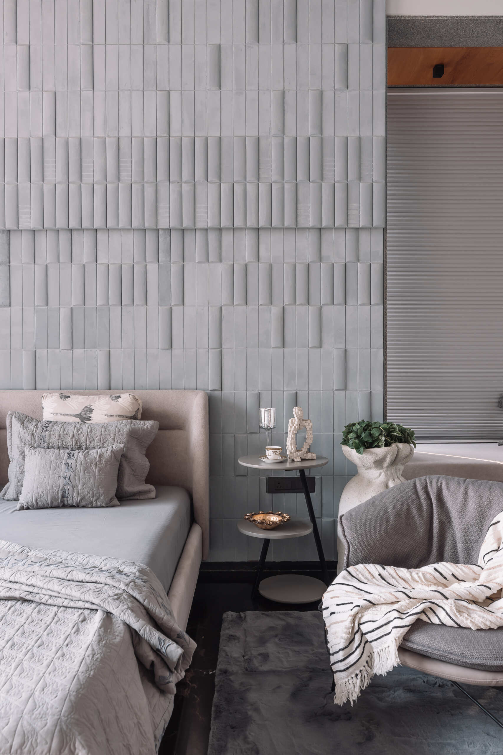 Grey textured walls, black floors and bold blue furniture give this contemporary bedroom a distinctive personality.