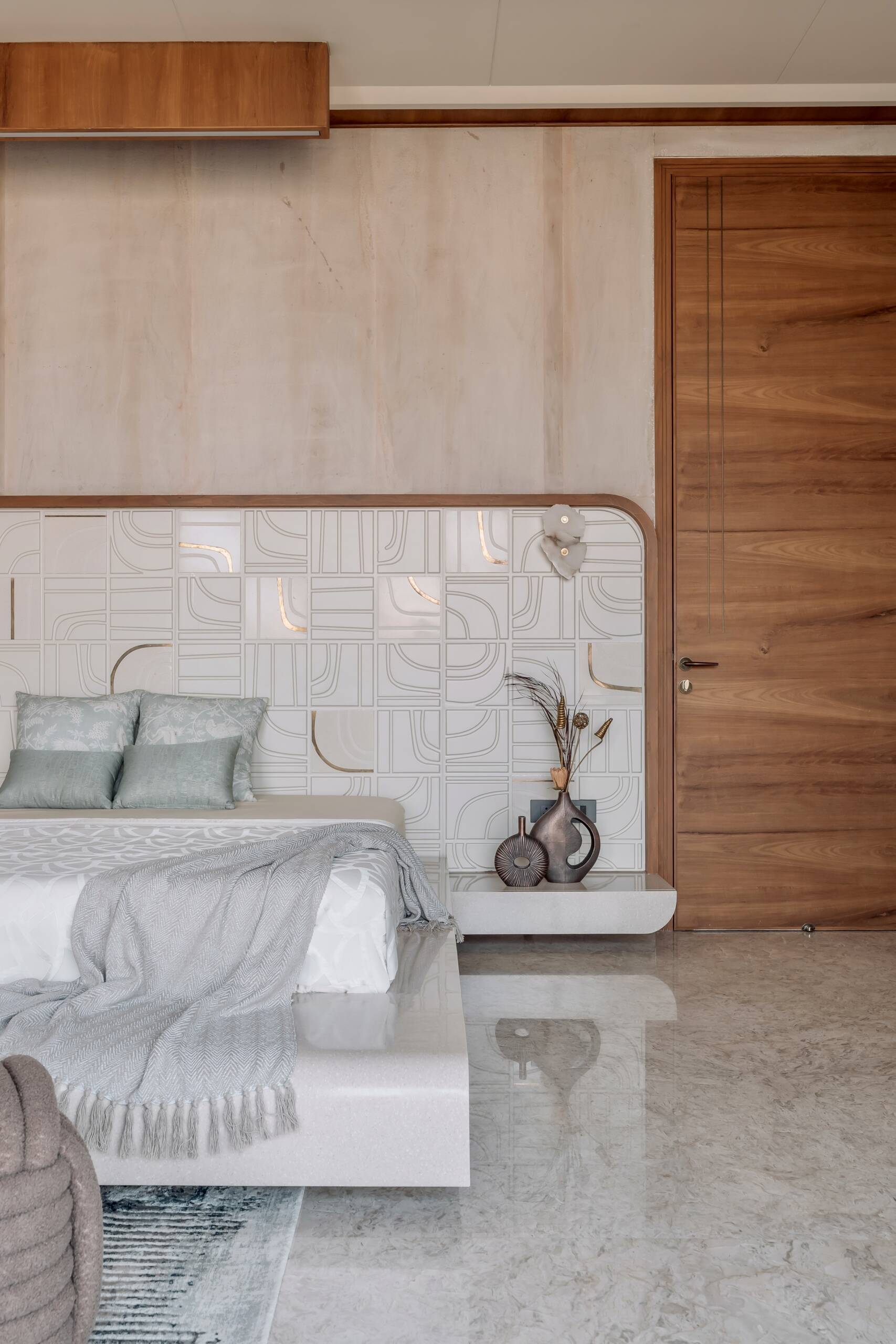 Sandstone walls, brass inlays and custom cabinetry give this elegant bedroom plenty of warmth and character.
