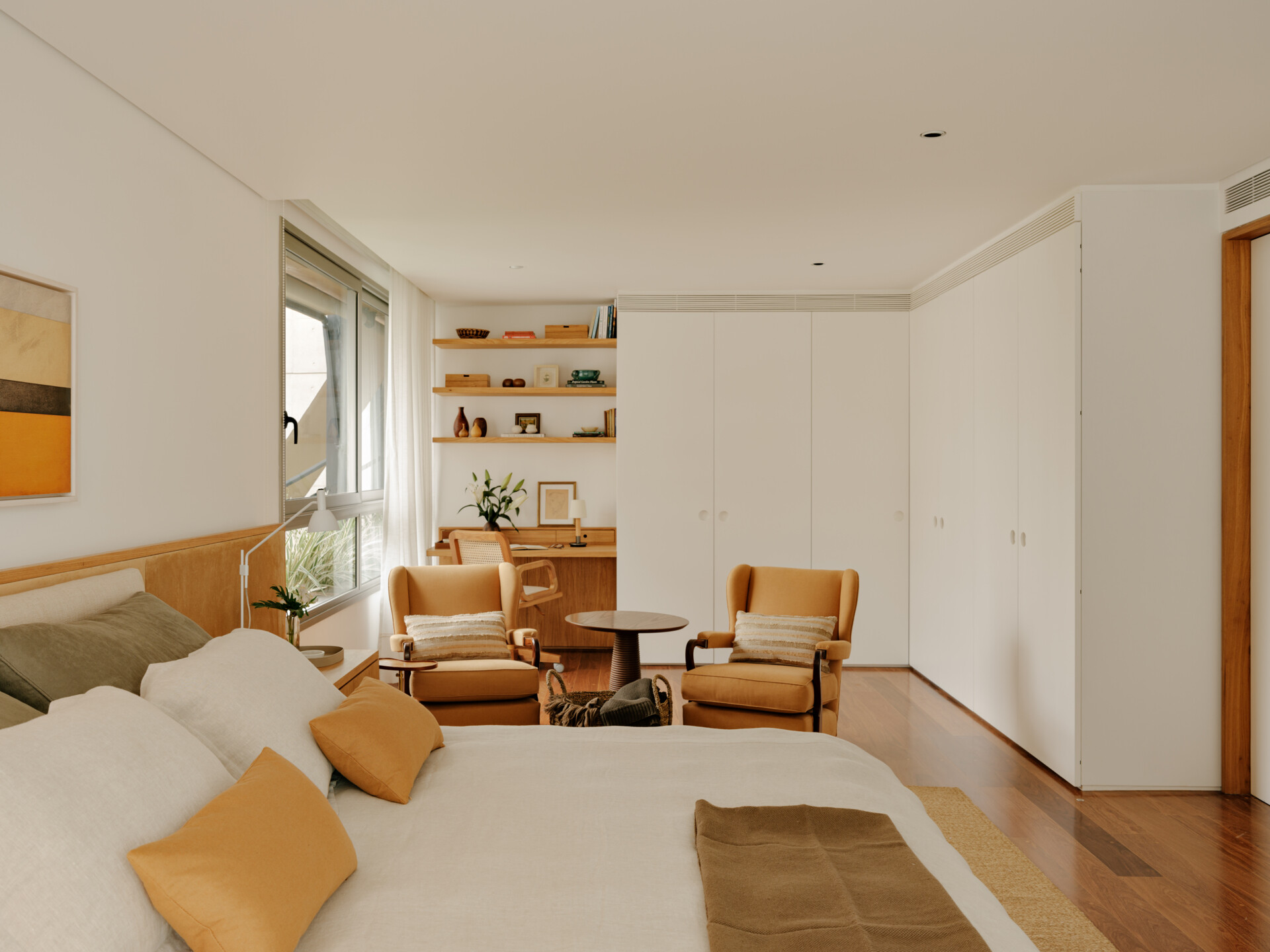 Family artwork inspired the colours of this warm contemporary bedroom filled with custom joinery and natural materials.