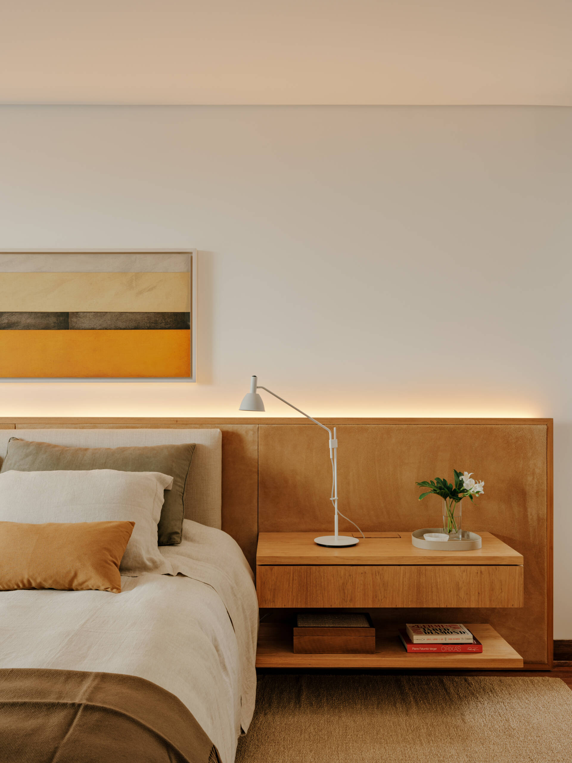 Family artwork inspired the colours of this warm contemporary bedroom filled with custom joinery and natural materials.