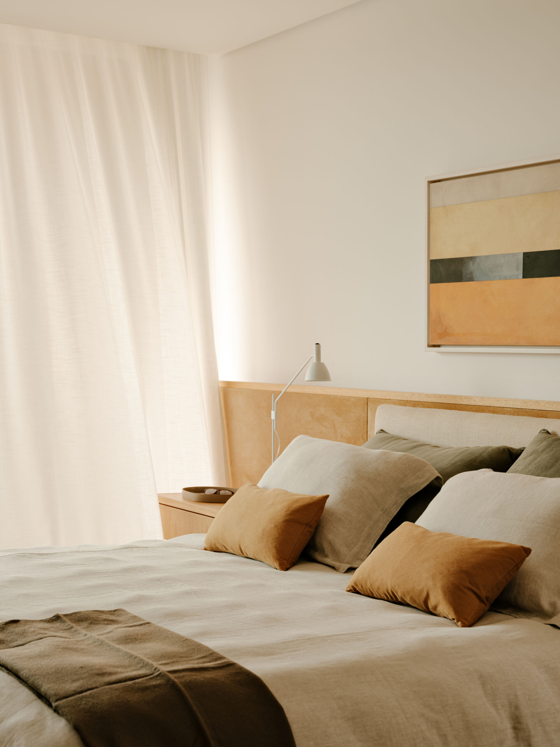 Family artwork inspired the colours of this warm contemporary bedroom filled with custom joinery and natural materials.