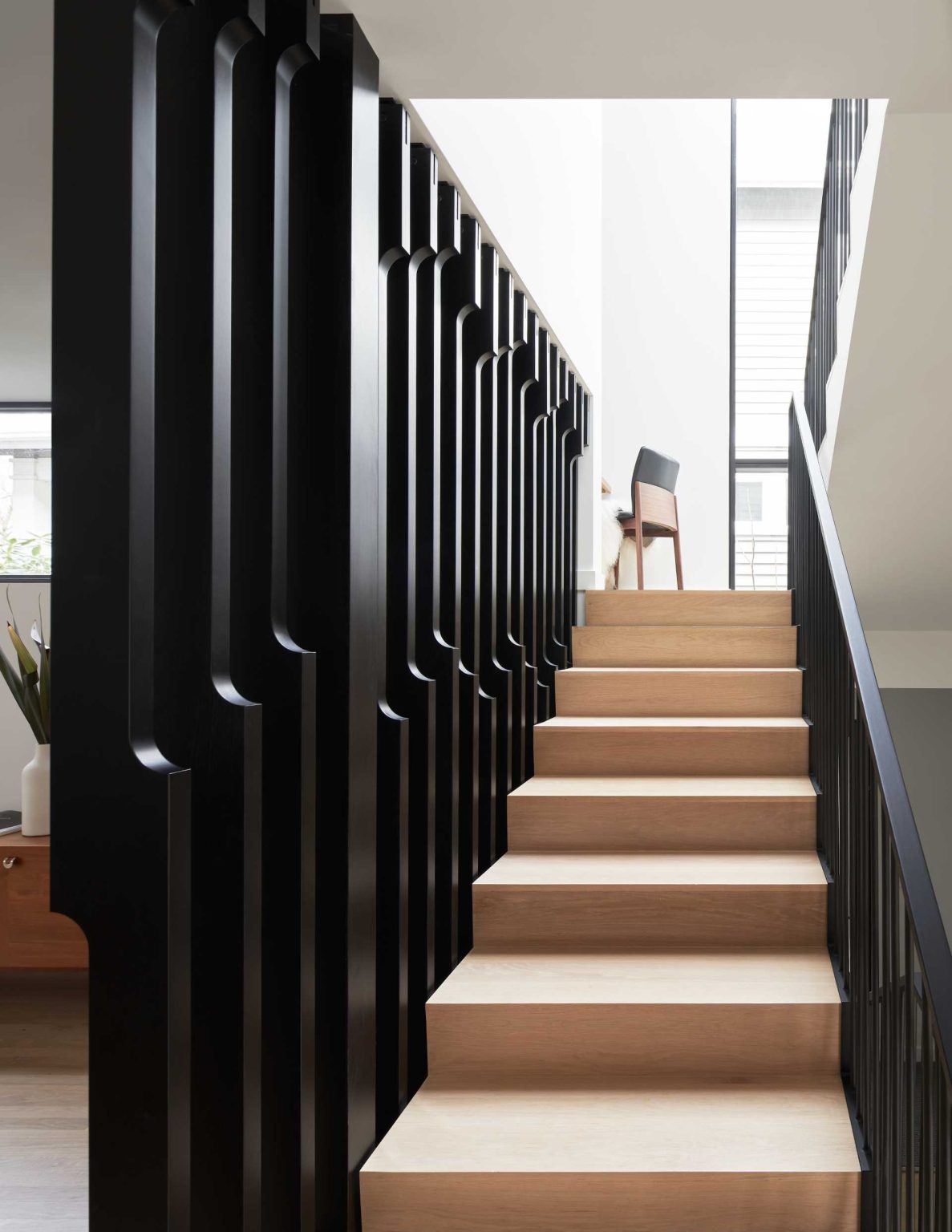 An undulating wood screen, skylight, and hidden office nook transform the staircase into one of the home's most memorable architectural features.