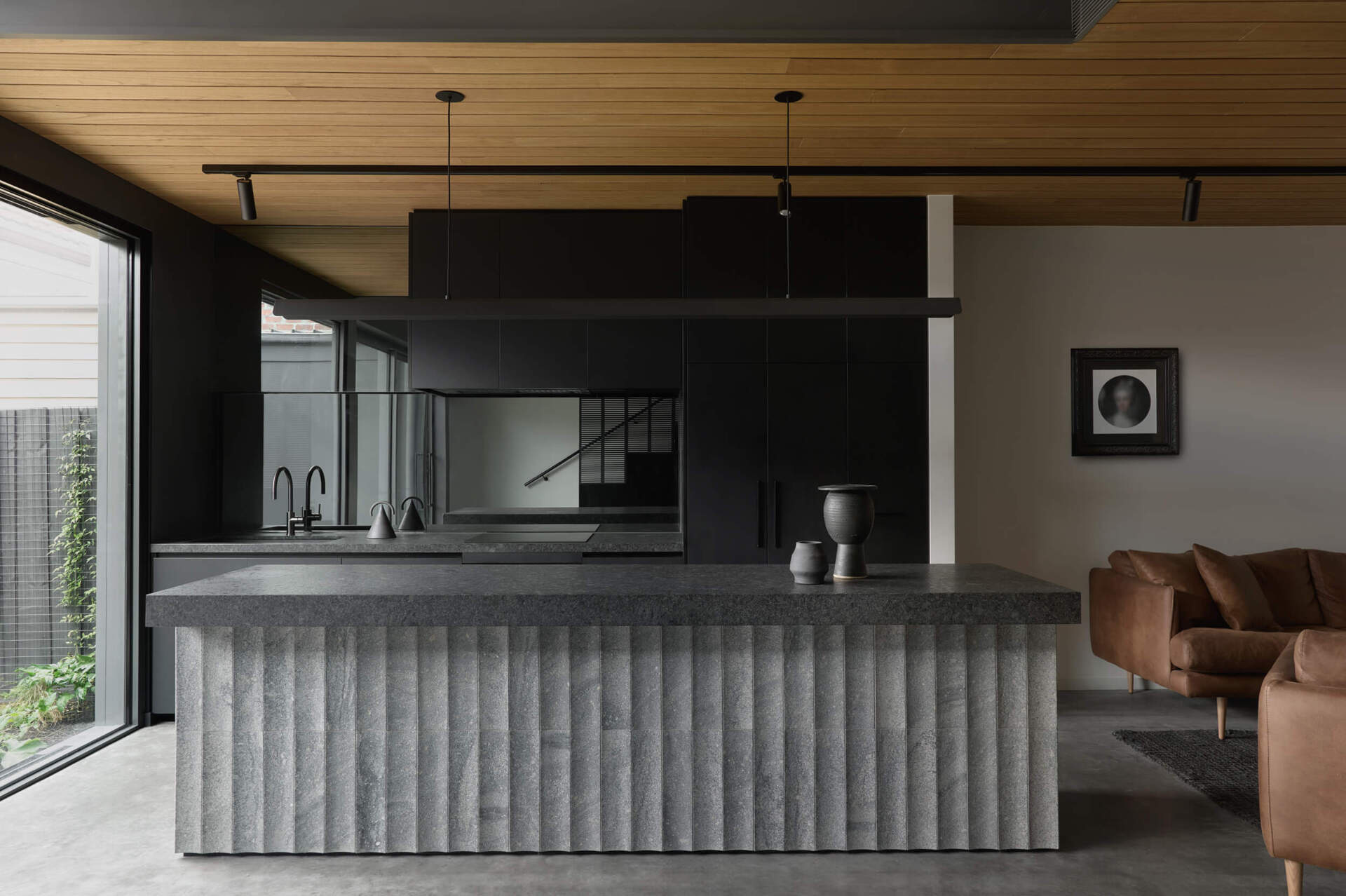 Floating steel, carved granite, recycled brick and blackbutt timber give this industrial-inspired kitchen a sophisticated modern look.