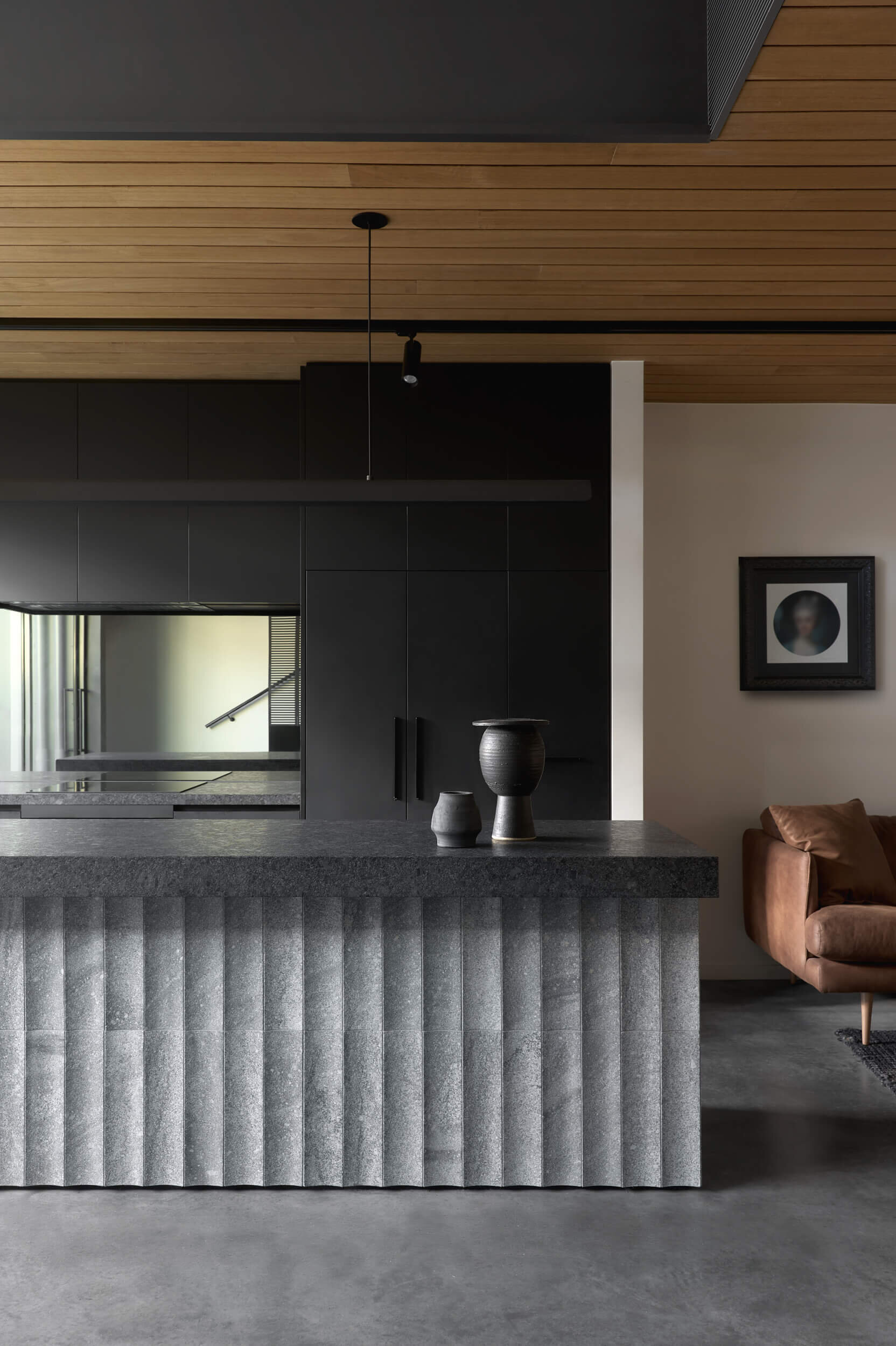 Floating steel, carved granite, recycled brick and blackbutt timber give this industrial-inspired kitchen a sophisticated modern look.