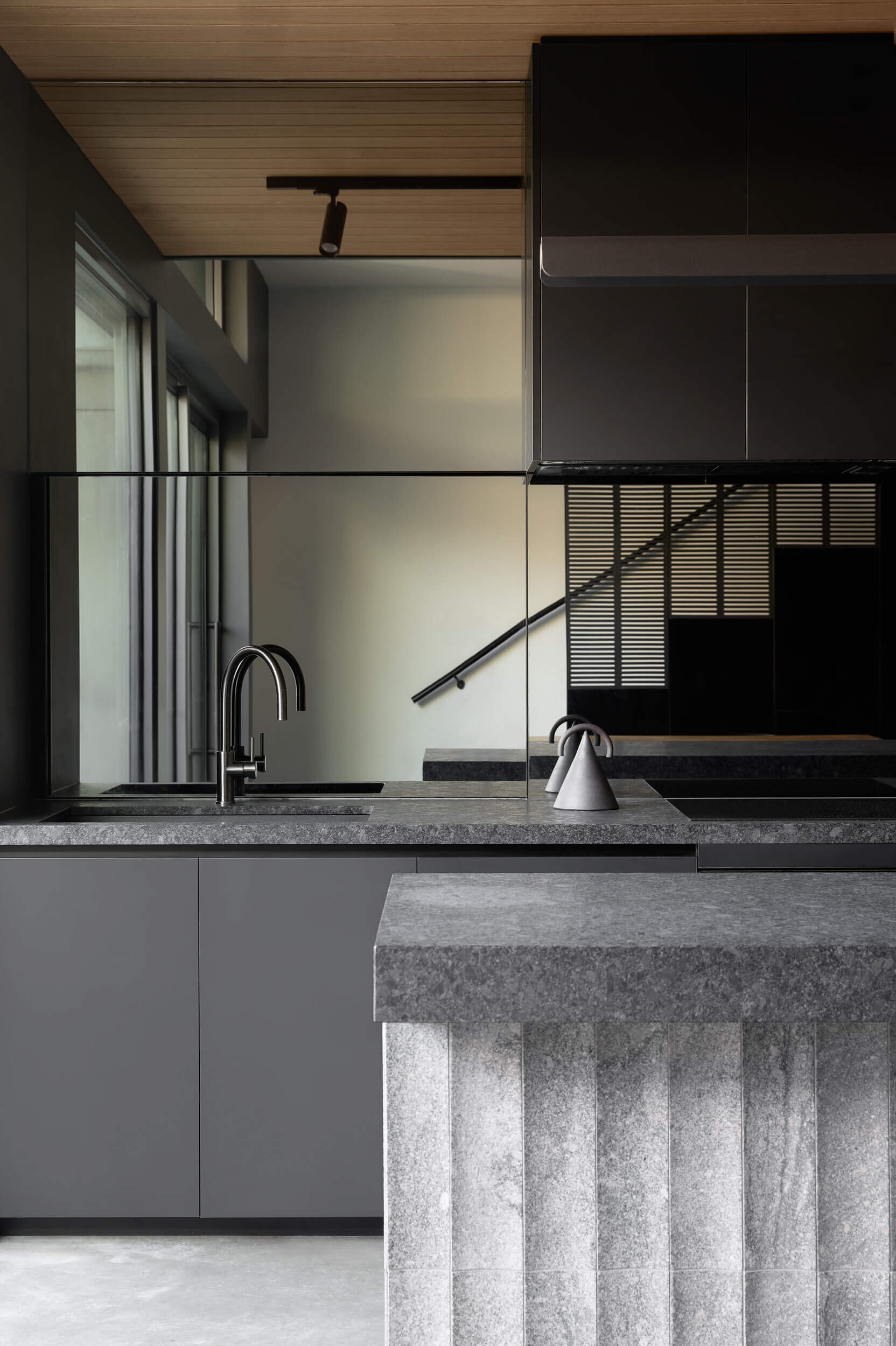 Floating steel, carved granite, recycled brick and blackbutt timber give this industrial-inspired kitchen a sophisticated modern look.