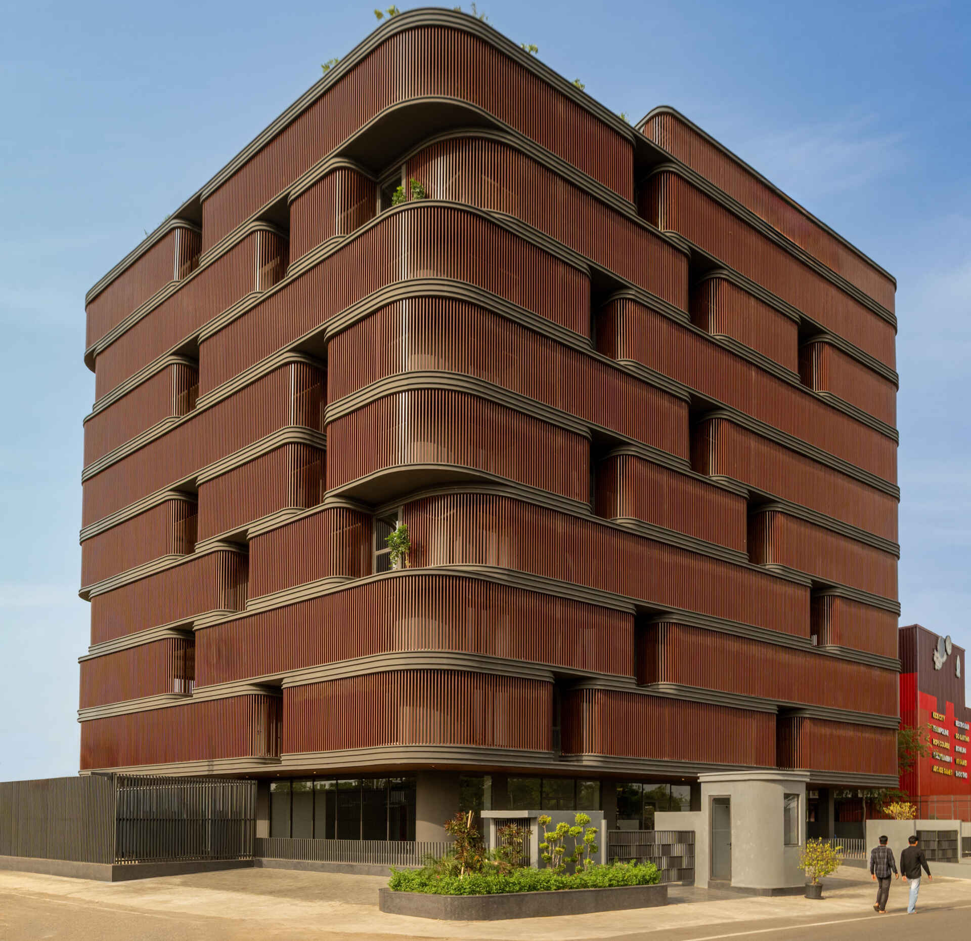 This office building combines capsule-shaped architecture, flexible workspaces, rooftop gardens, planter terraces, natural ventilation, and passive cooling strategies to create a greener, more comfortable workplace in one of India's hottest climates.
